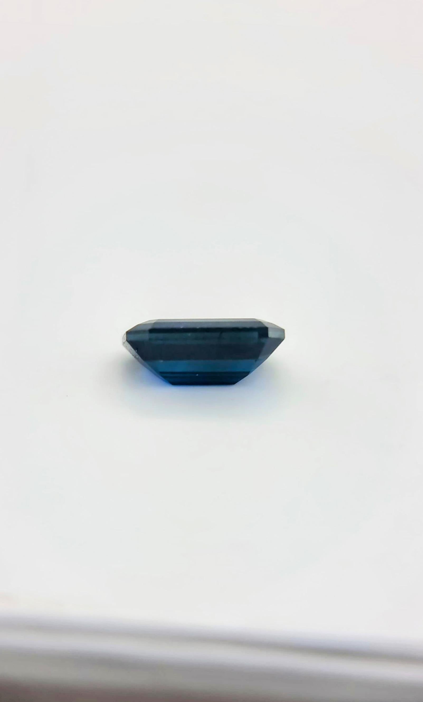 Dieser natürliche dunkelblaue Saphir mit einem Gewicht von 2,10 Karat ist in einer rechteckigen Form mit abgeschrägten Ecken geschliffen. Der Edelstein misst etwa 7,4 mm in der Länge und 3,8 mm in der Breite und hat einen dunkelblauen Farbton mit