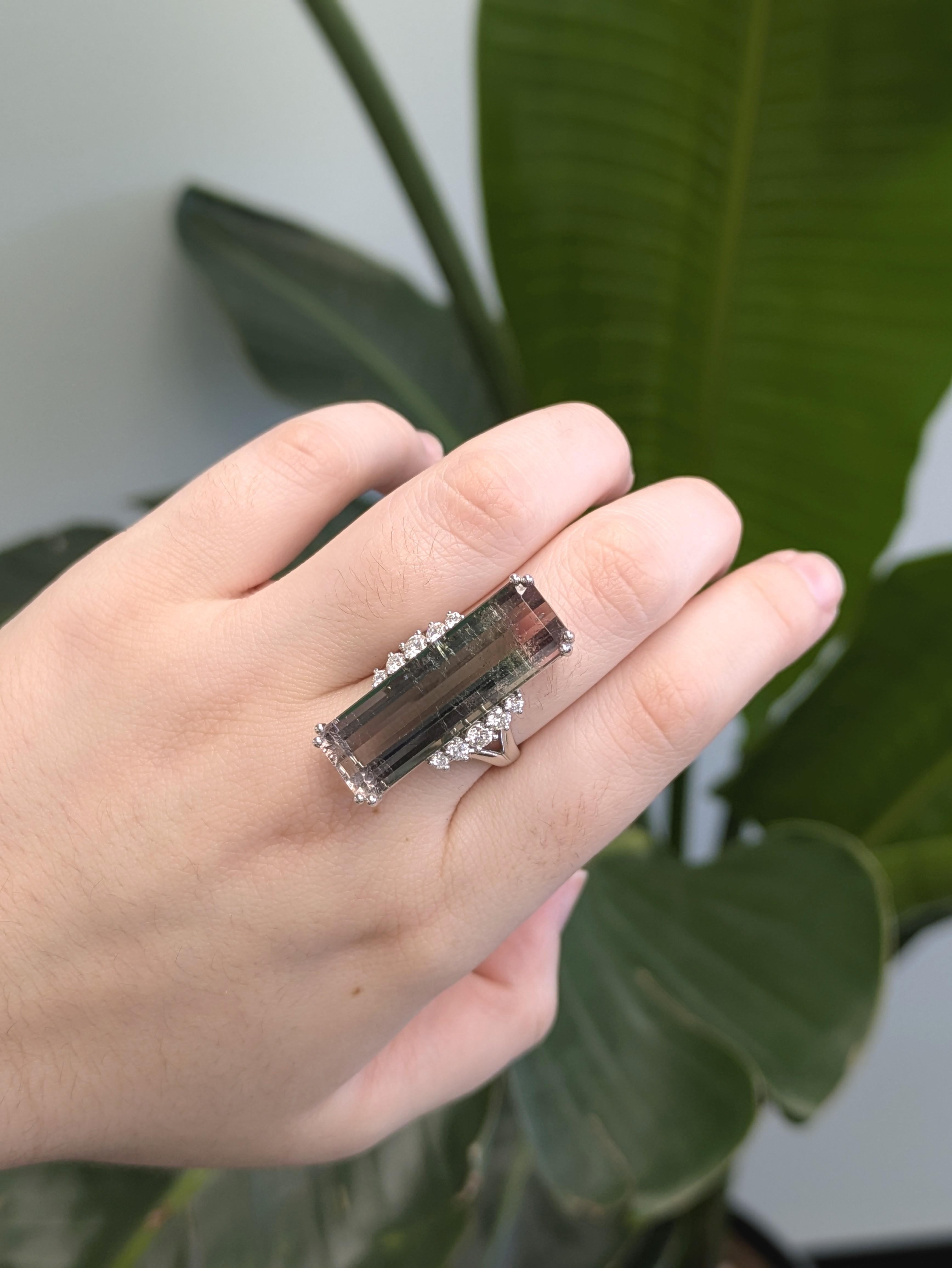 Fai una dichiarazione audace con questo splendido anello con tormalina bicolore da 21 carati, che presenta una rara miscela naturale di tonalità verdi e rosa in una gemma di 29,7 x 10 mm. Proveniente dal Brasile, rinomato per le sue tormaline di
