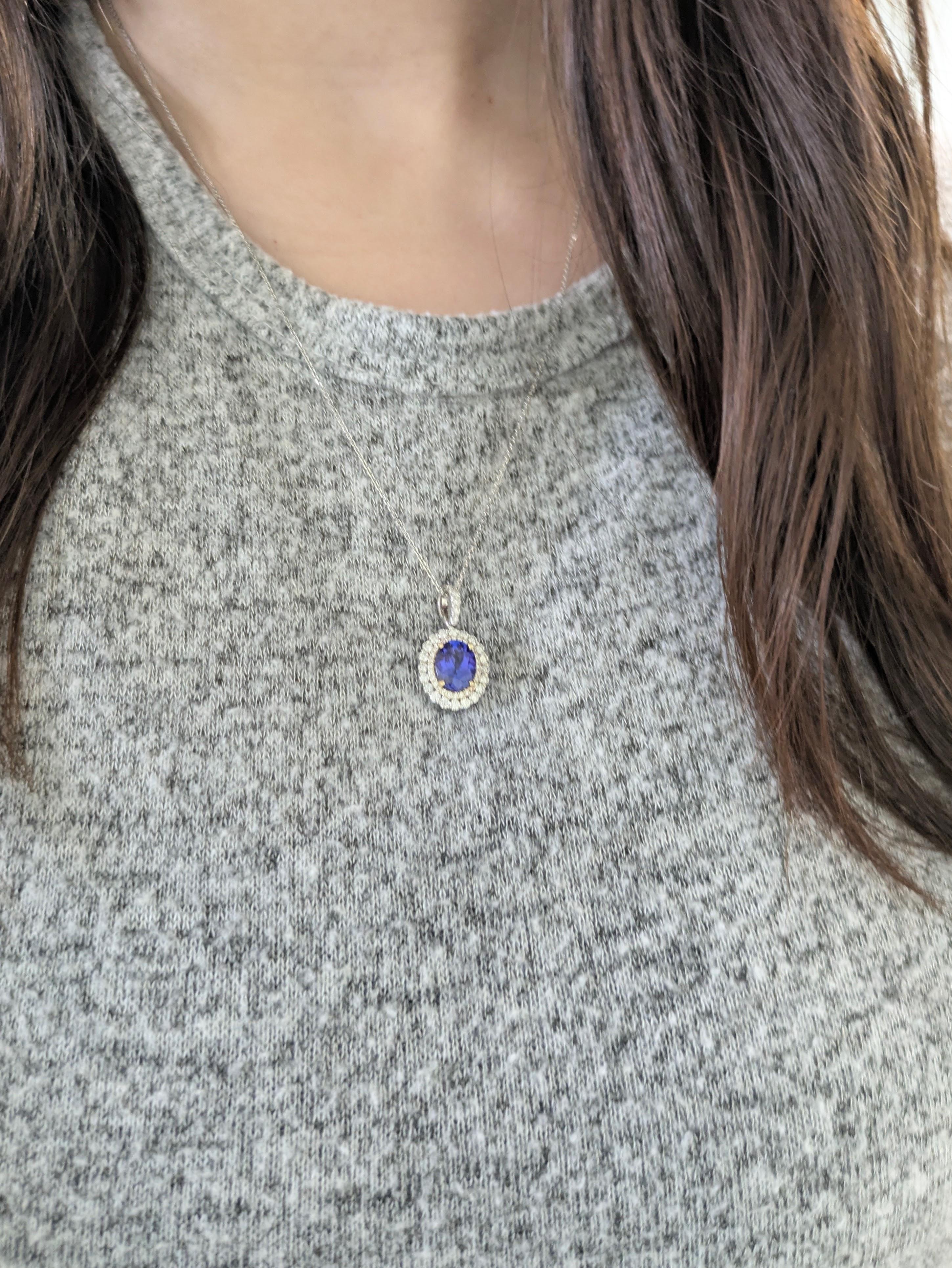 Un captivant pendentif ovale en tanzanite serti dans un luxueux or blanc et jaune massif 14k, entouré d'un halo étincelant de diamants naturels. Cette pièce élégante rayonne de couleurs vibrantes et de sophistication intemporelle - une véritable
