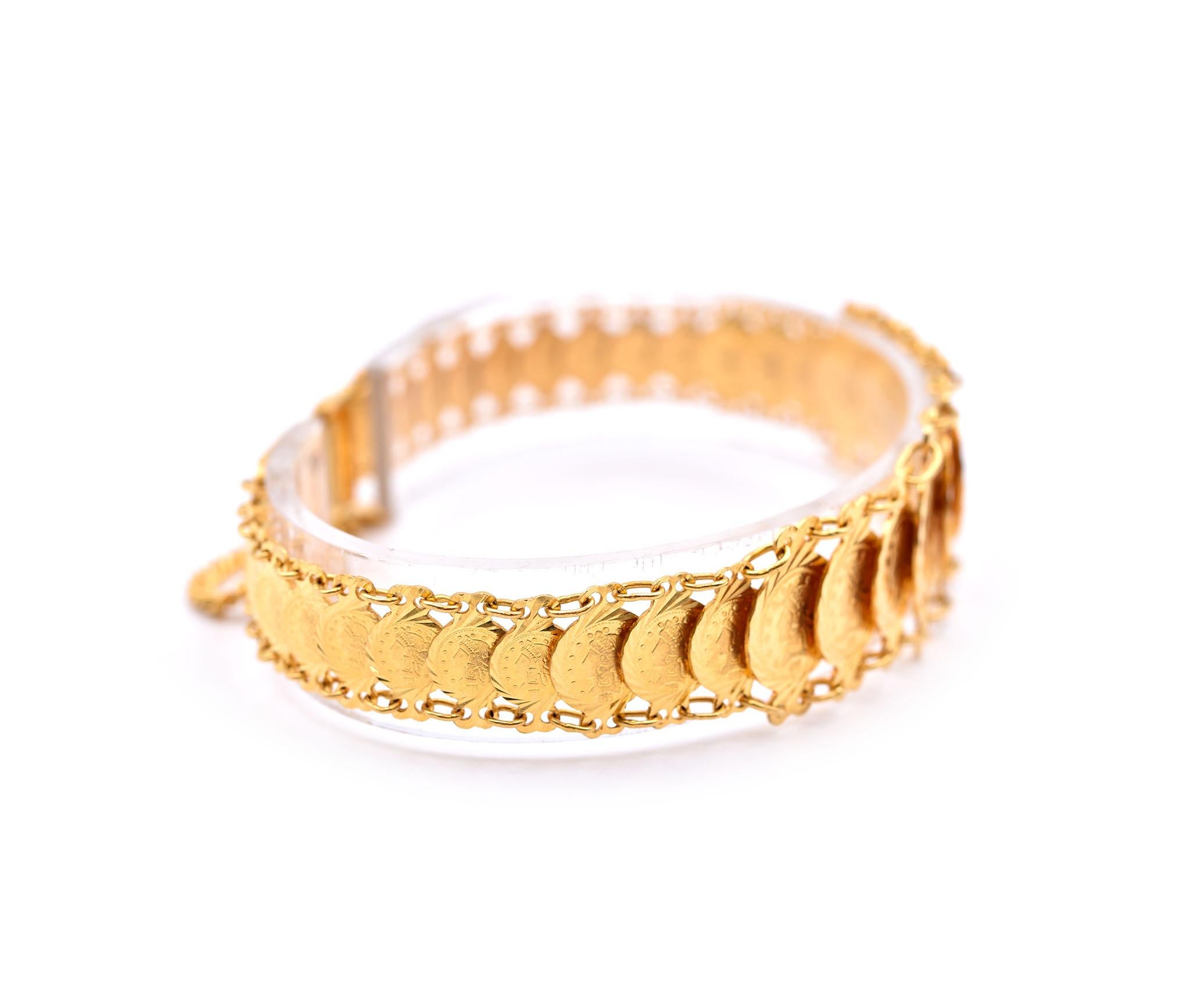 Designer: custom design 
Material: 21k yellow gold
Dimensions: bracelet will fit a 6.5-inch wrist, bracelet is 18.45mm wide
Weight: 23.19 grams
