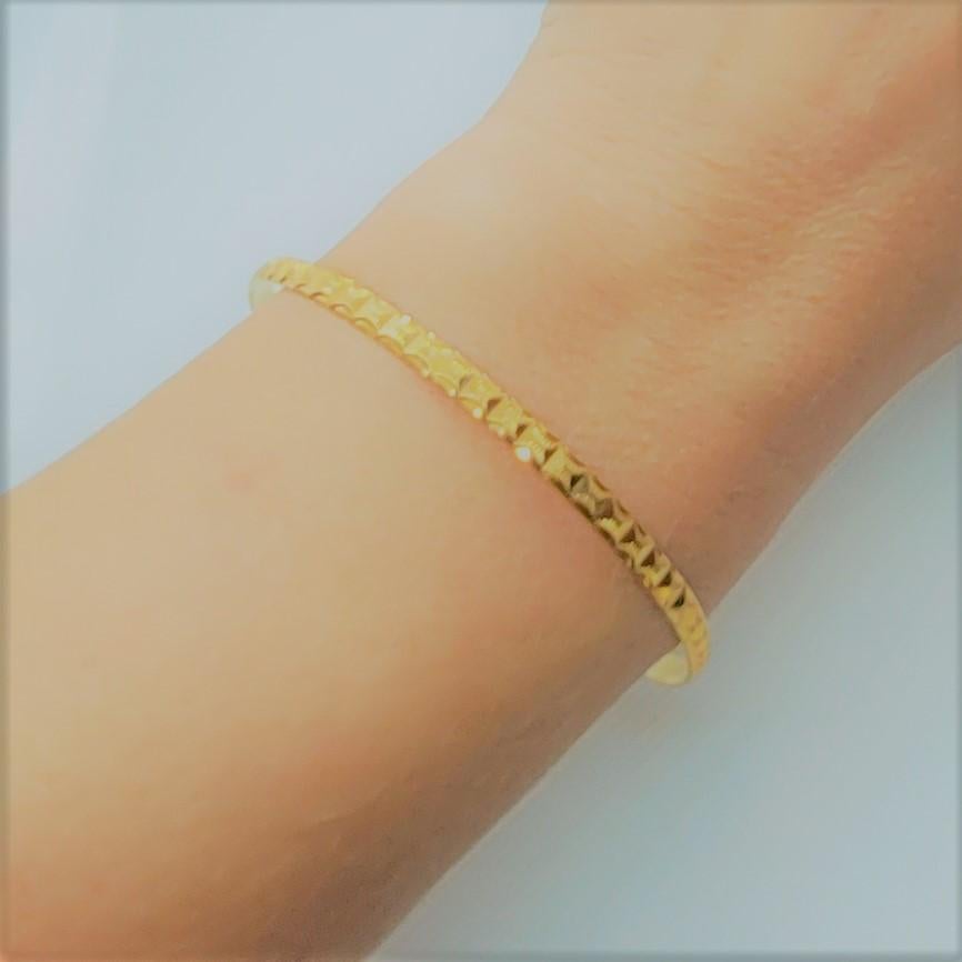 Beautiful 21kt gold bangle bracelet that weighs 9.70 grams. The bracelet has a lovely diamond-cut design, is 3.5mm wide, 1.1mm thick and the diameter is approximately 2.75 inches or 70mm. The inside of the bangle is stamped AS21K. Please feel free