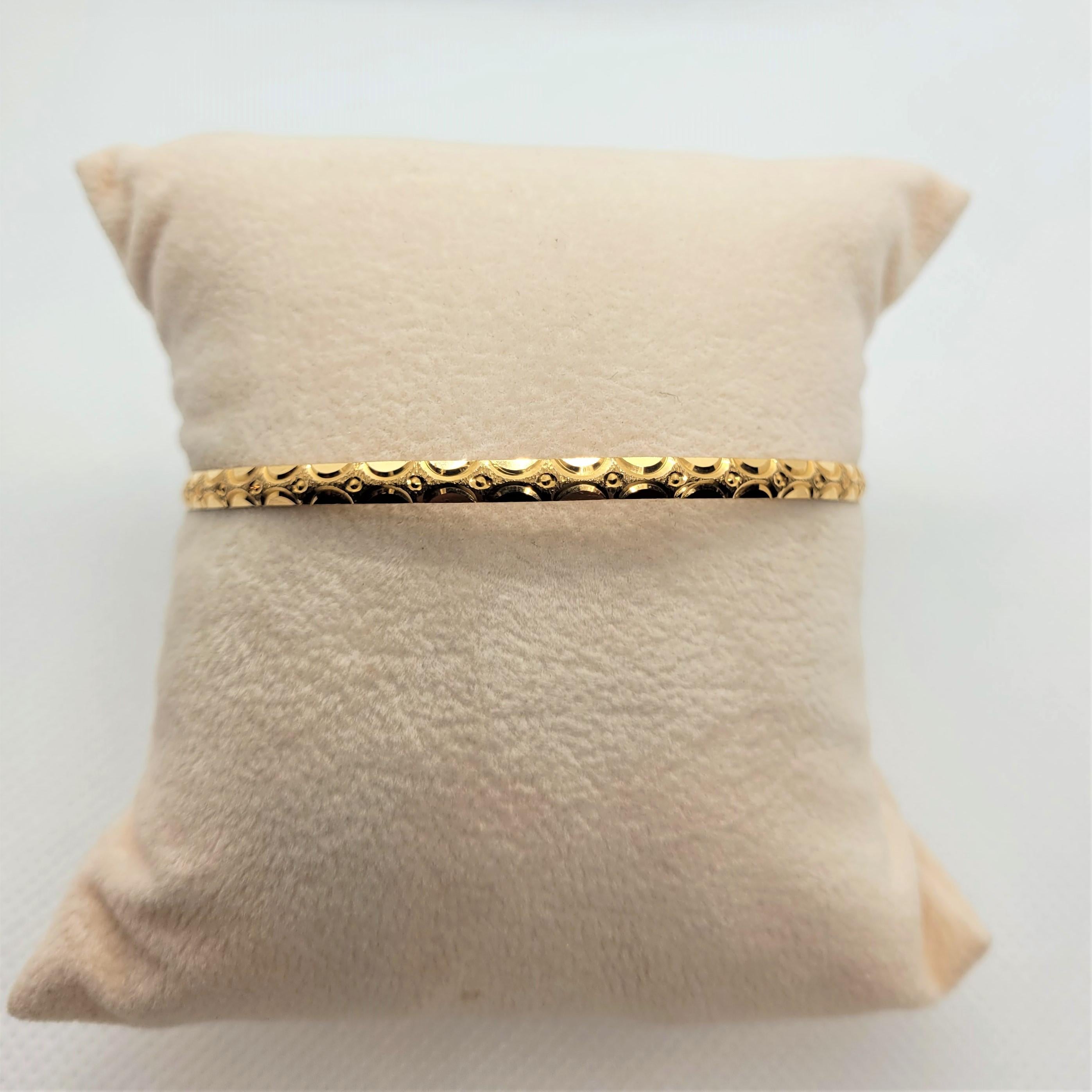 Beautiful 21kt gold bangle bracelet that weighs 9.74 grams. The bracelet has a lovely diamond-cut design, is 3.4mm wide, 1.15mm thick and the diameter is approximately 2.75 inches or 70mm. The inside of the bangle is stamped AS21K. Please feel free