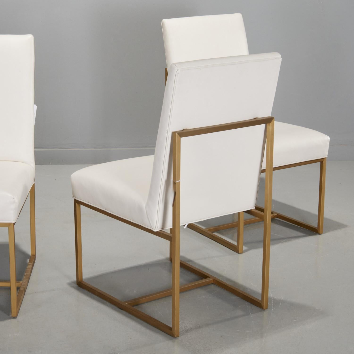 21e c.,  Un ensemble de quatre chaises latérales contemporaines en cuir blanc dans le style de Milo Baughman, avec des cadres en métal doré, non marqués.  Ces chaises proviennent d'une résidence décorée par l'incomparable designer/architecte  Daniel