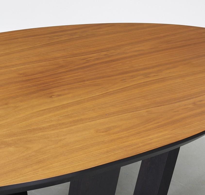 21st century oval walnut top dining table on black lacquered cruciform base, unmarked. A beautiful contemporary dining table with wonderful wood grain and surface. The cruciform base allows for comfortable seating for all guests. Similar tables sell