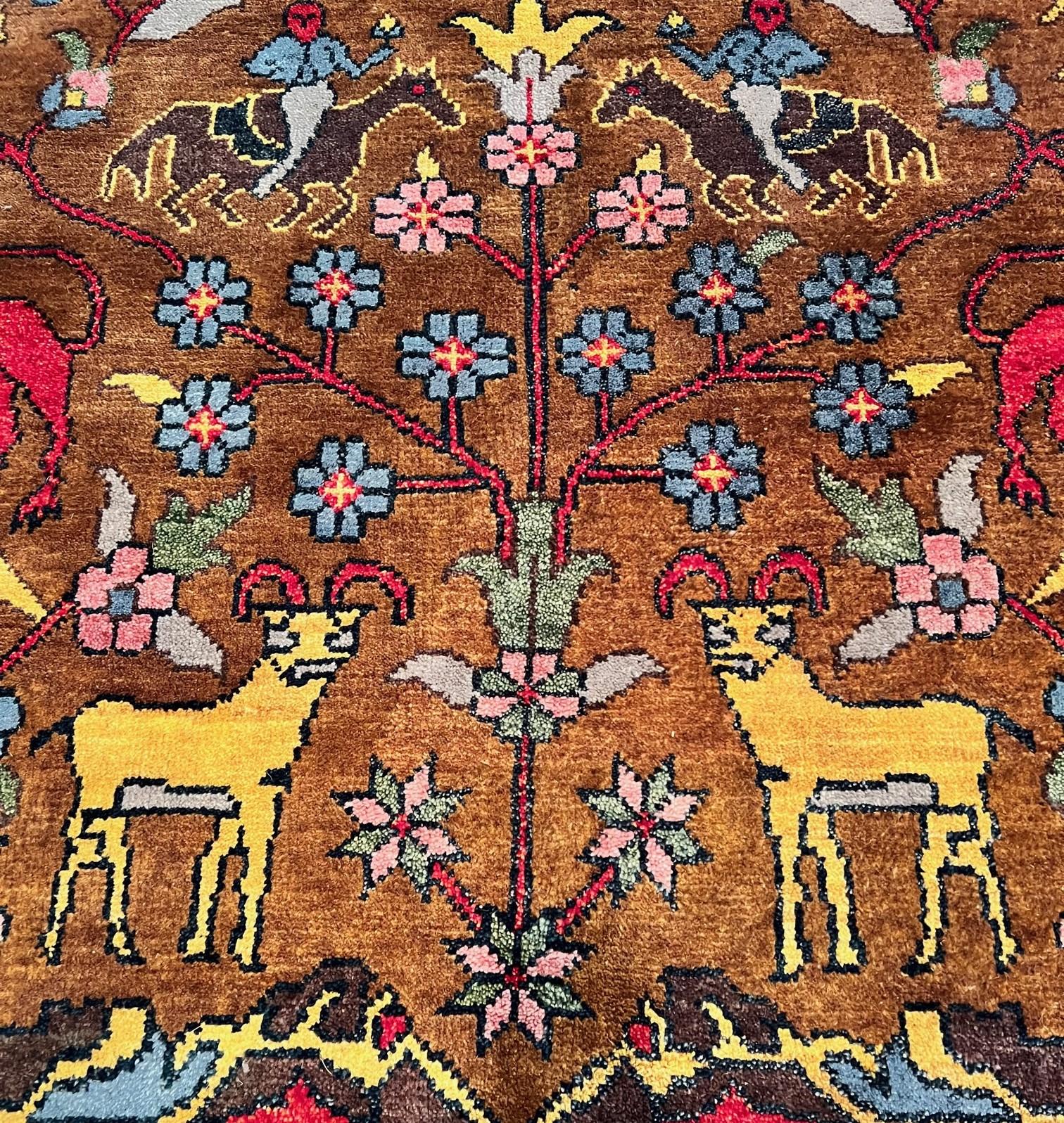 21st C. a Bijar-style Indian area rug in brilliant colors, richly depicting animals flowers and Cyprus trees. The field color is a lovely chocolate brown with an off white border. Camels and flowers decorate the border while the main section