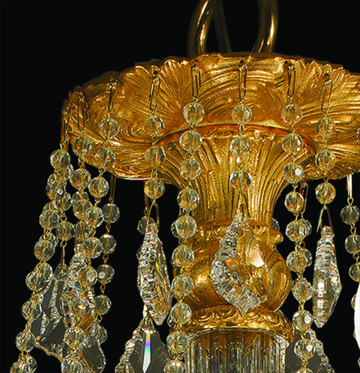 12-Lights chandelier in clear crystal and gold patinated bronze. 
The parts in crystal are hand-carved. Each object is handcrafted and the care for every detail makes each item unique in its kind. The style of this chandelier is a modern