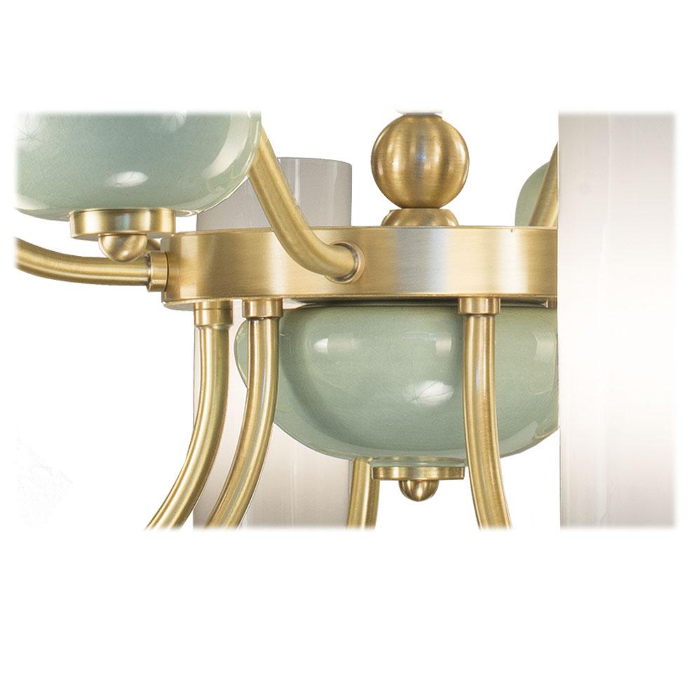 Lampadario a 12 luci in porcellana verde chiaro e bronzo brunito. Ogni oggetto è realizzato a mano e la cura di ogni dettaglio lo rende unico nel suo genere. I paralumi sono in vetro satinato. 
Lo stile di questo lampadario è una reinterpretazione