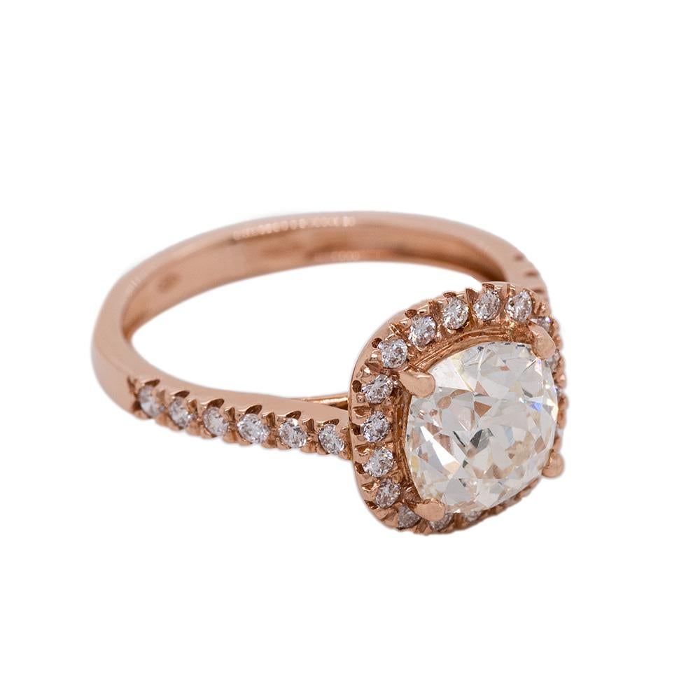 Behold the mesmerizing beauty of this 21st-century designed 18-karat rose gold ring, adorned with an enchanting array of diamonds. The centrepiece of this ring is a magnificent white, old mine-cut antique cushion diamond, boasting an impressive 2.25