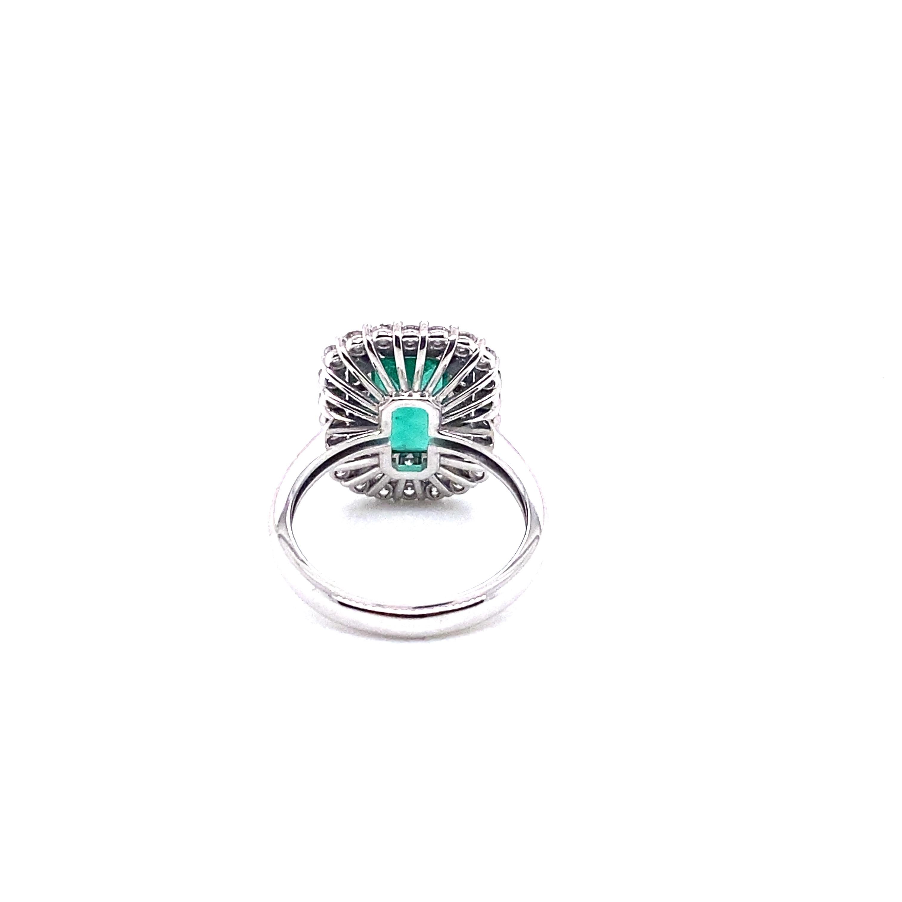 A spectacular, octagon-cut emerald weighing 6.1 carats is surrounded by two rows of diamonds rated G VS and weighing 1.04 carats and is set in beautiful 18-karat white gold for this magnificent ring. This cocktail ring was hand-made using