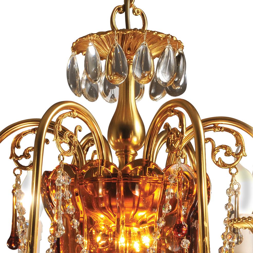 6-Lights chandelier in amber  crystal and gold patinated bronze, with  clear and amber  pendants in murano glass. 
The parts in crystal are hand-carved. Each object is handcrafted and the care for every detail makes each item unique in its kind. The