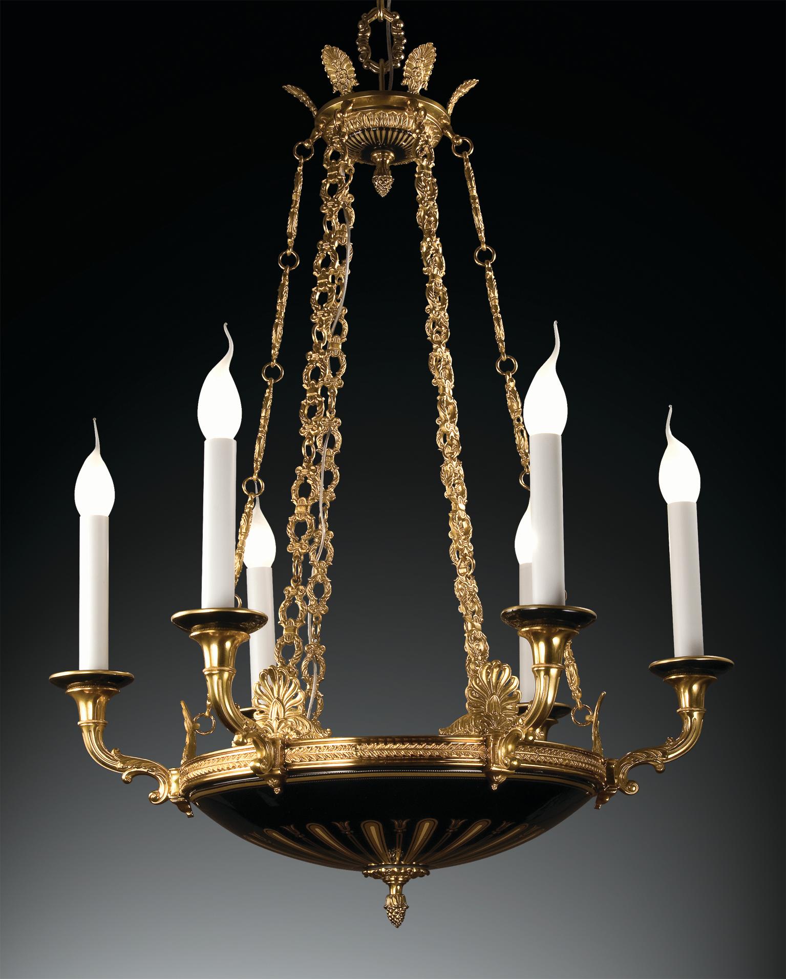 6-lights chandelier in decorated black porcelain and gold patinated bronze. 
The porcelain is decorated in pure gold. Each object is handcrafted and the care for every detail makes each item unique in its kind. The style of this chandelier is a