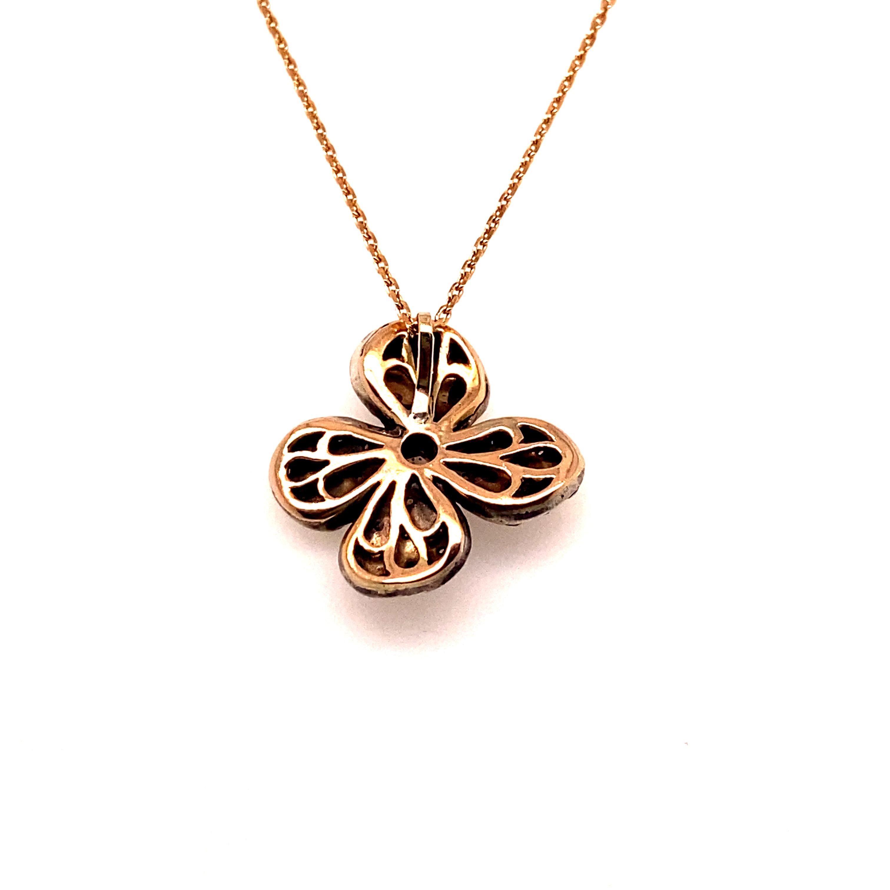 Ce pendentif et cette chaîne en forme de fleur, créés de main de maître en or rose 9 carats et en argent 925, sont sertis d'une poignée de diamants blancs taillés en rose soigneusement sélectionnés. 

Le pendentif en forme de fleur mesure 2