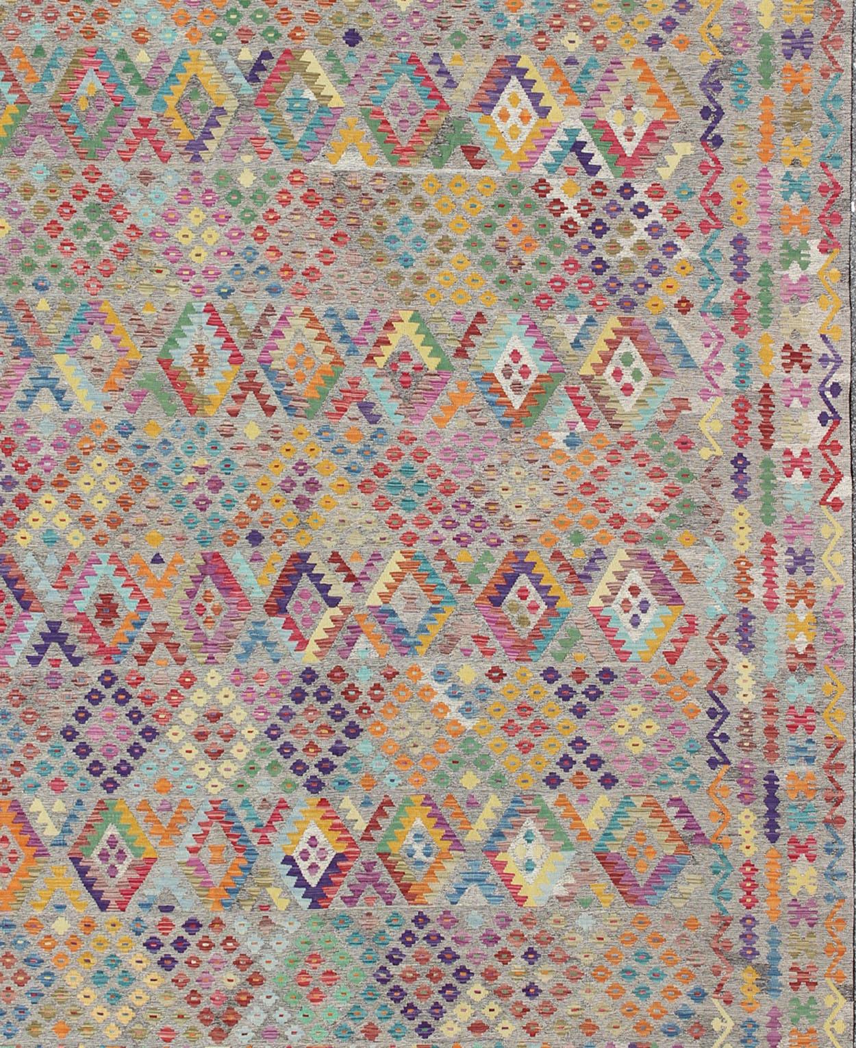 Dieser große, handgewebte afghanische Kelimteppich zeigt ein wunderschönes geometrisches Muster in einer Reihe von Regenbogenfarben, darunter Rot, Blau, Orange, Rosa, Lila, Elfenbein und Grün.

Keivan Woven Arts, ABT-8121559, Afghanischer
