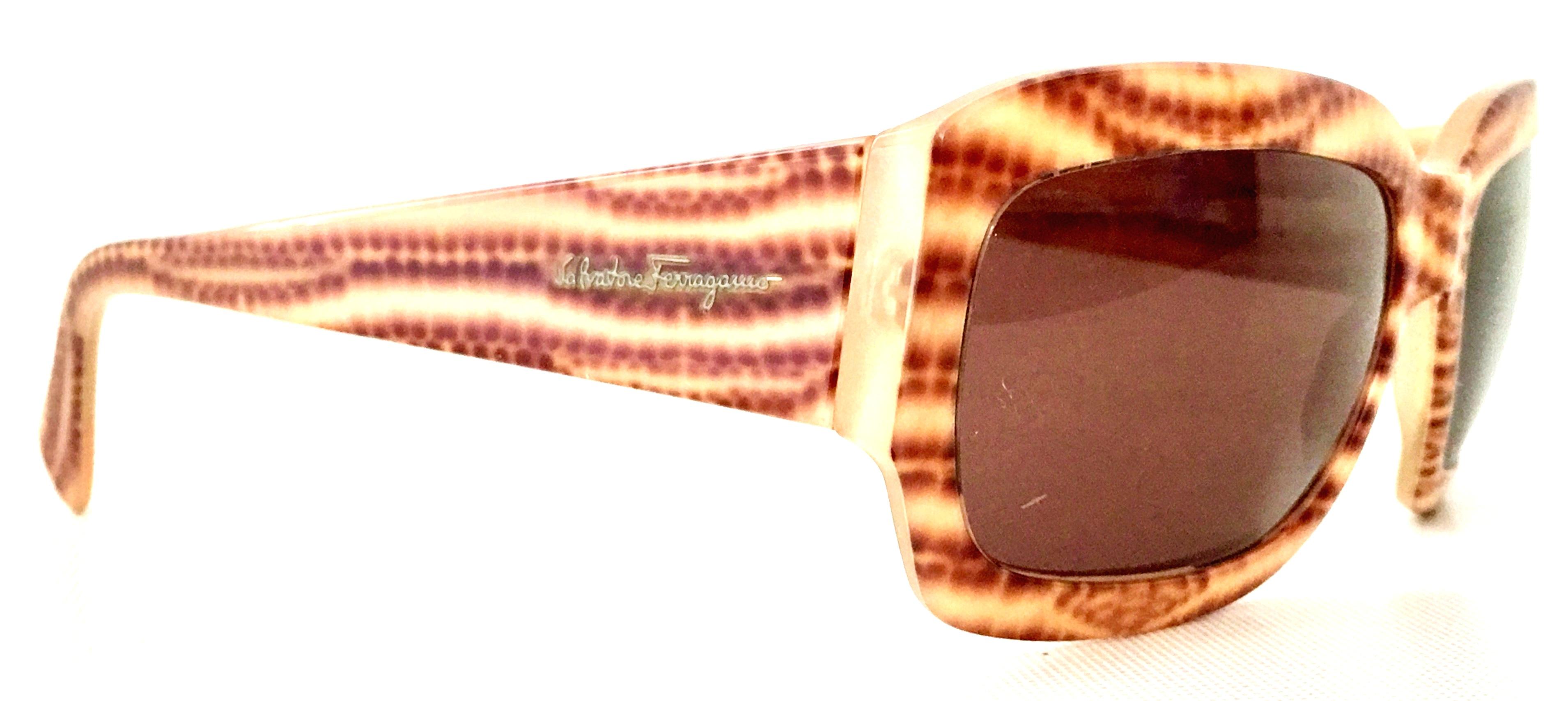 21st Century Salvatore Ferragamo abstract animal print sunglasses with original gift box. These acetate Ferragamo sunglasses Feature a subtle amethyst tinted lens with shades of brown animal print frames and the gold raised font logo at each