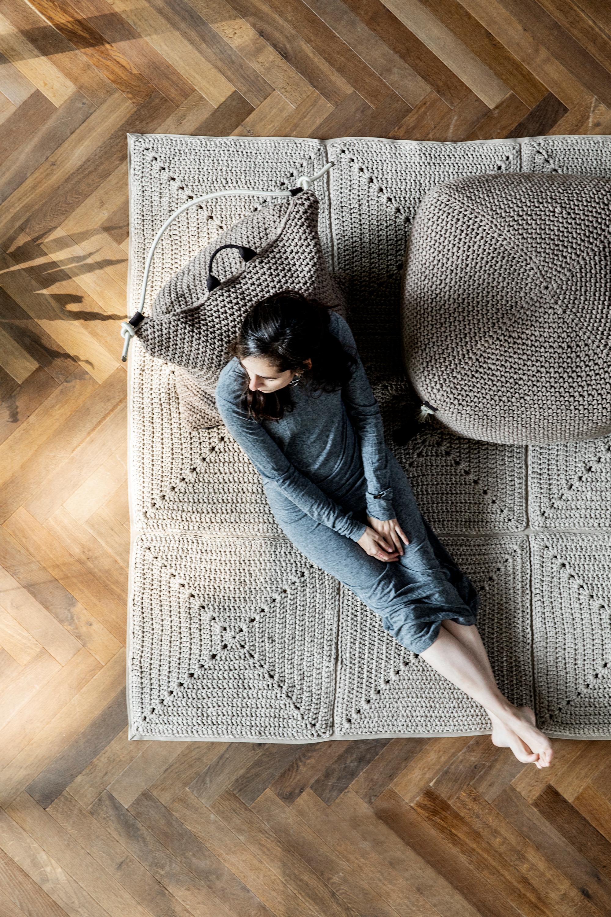 The classic crochet granny square takes a contemporary twist in this outdoor rug. Large squares form the rug, framed with bespoke webbing. Handmade from UV protected bespoke iota yarn in earth tones, the textile is soft, yet durable and suitable for