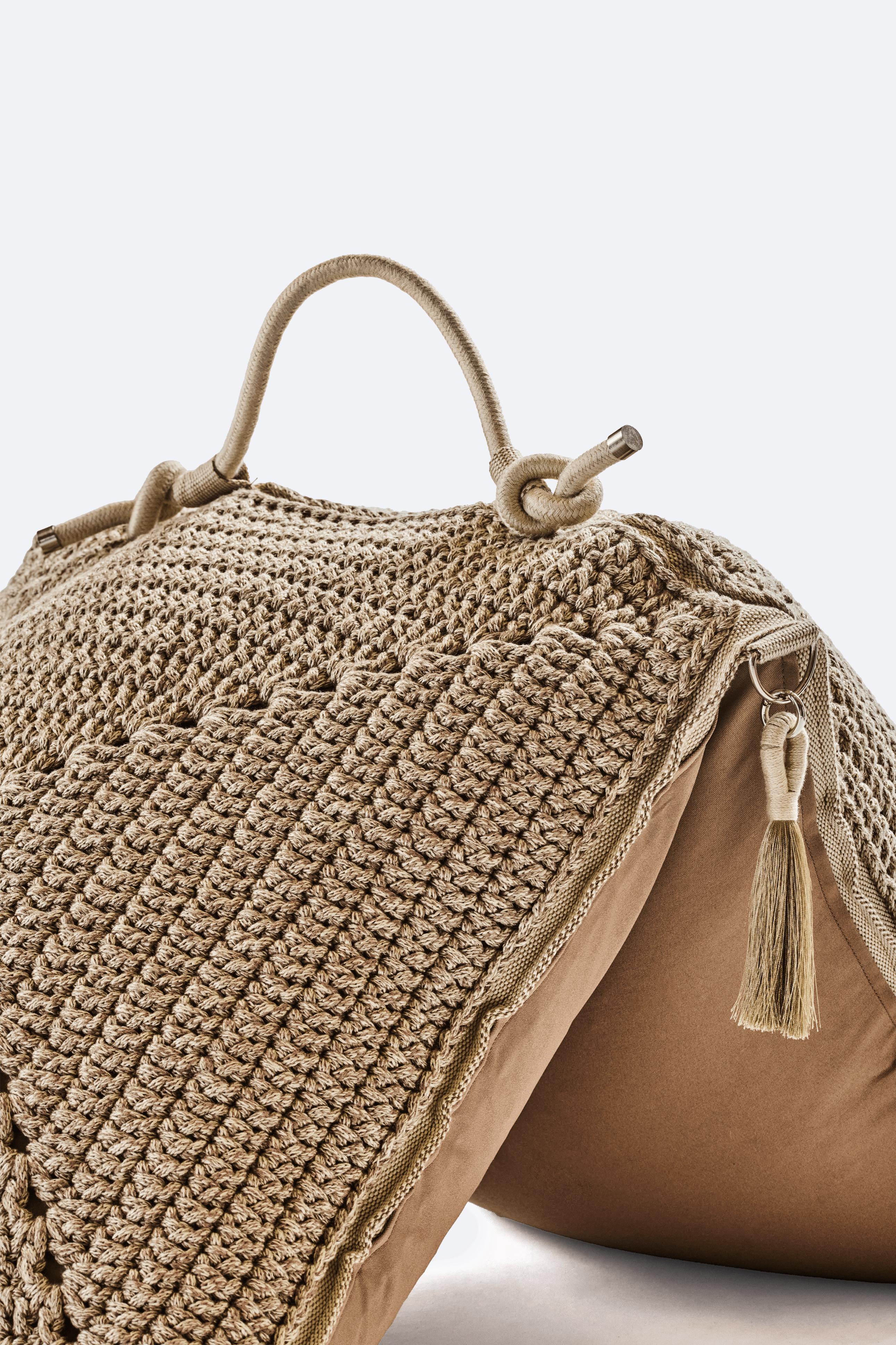 Das klassische gehäkelte Granny Square erhält mit diesem großen Bodenkissen eine moderne Note. Das Kissen besteht aus zwei Quadraten, die mit einem maßgeschneiderten Outdoor-Gurtband zusammengenäht werden. Sie erforscht die Ästhetik von Nomaden und