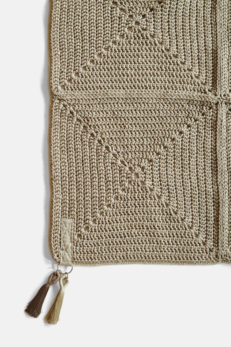 The Classic crochet granny square takes a contemporary twist in this outdoor rug. Large squares form the rug, framed with bespoke webbing. Handmade from UV protected bespoke iota yarn in earth tones, the textile is soft, yet durable and suitable for