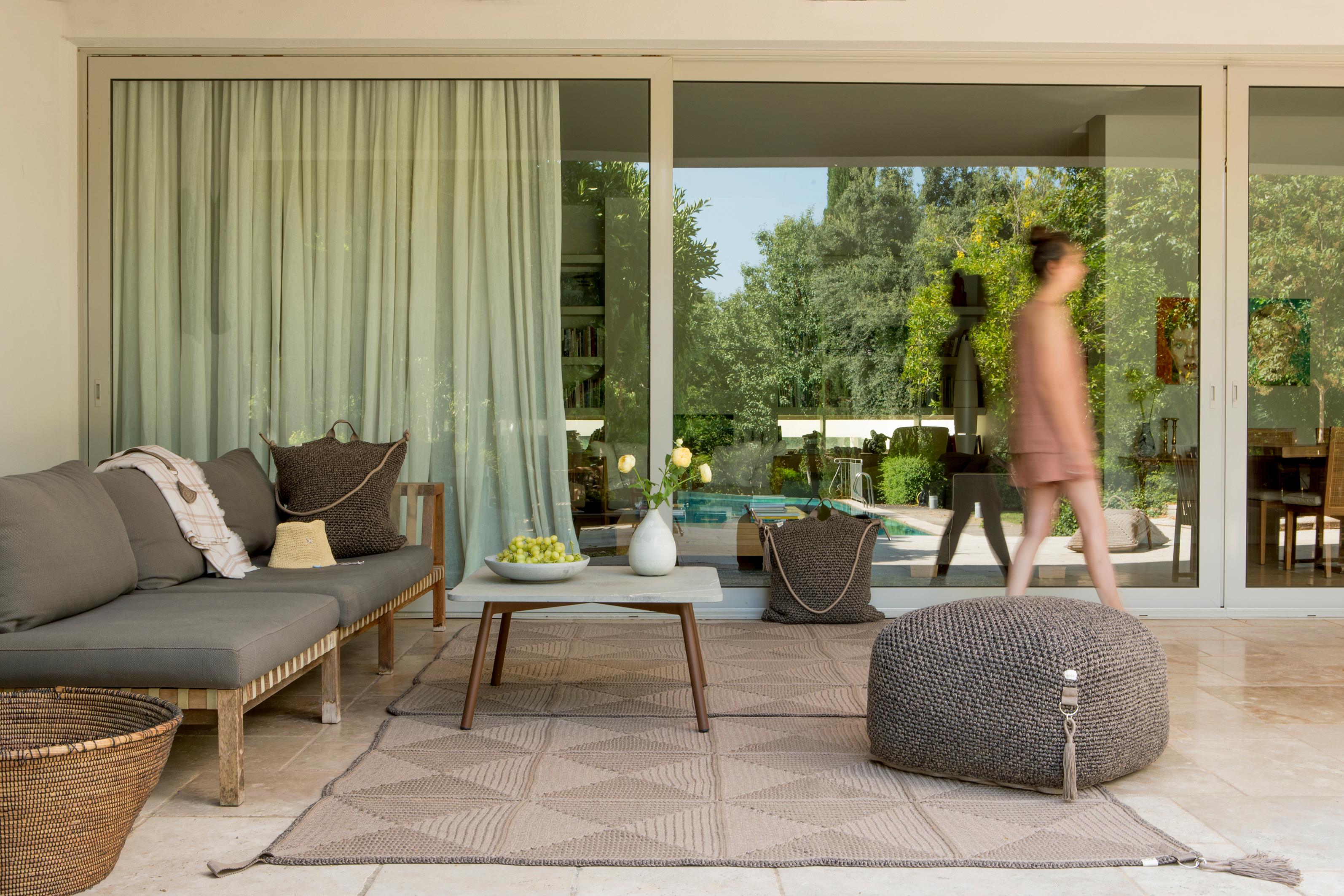 The Classic crochet granny square takes a contemporary twist in this outdoor rug. Large squares form the rug, framed with bespoke webbing. Handmade from UV protected bespoke iota yarn in earth tones, the textile is soft, yet durable and suitable for