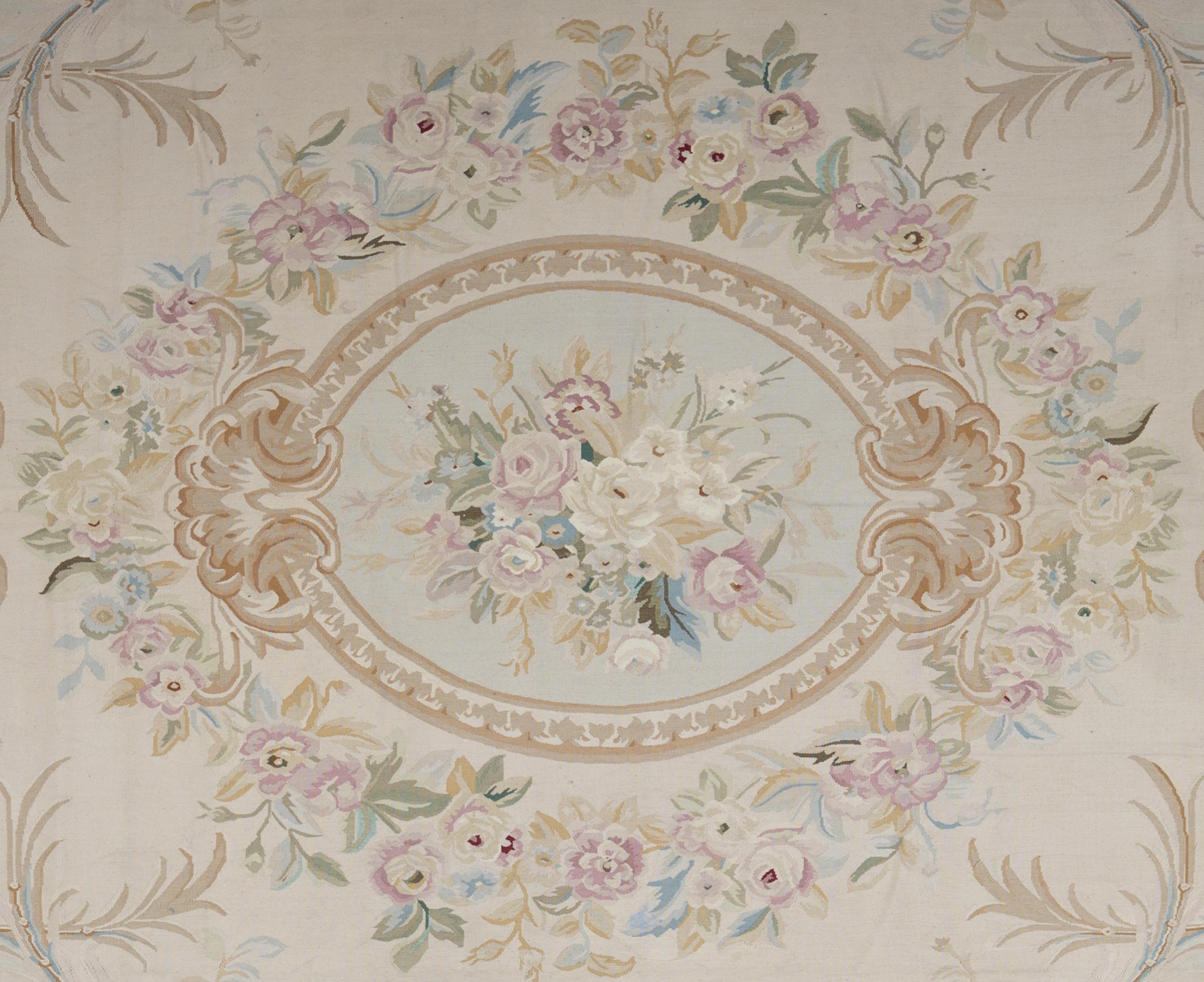 This light-toned Aubusson rug embodies the refined elegance of French neoclassical design, woven with a soft and graceful palette of ivory, blush, pale blue, and muted sage. Handwoven in wool, it features delicate floral garlands, scrolling acanthus