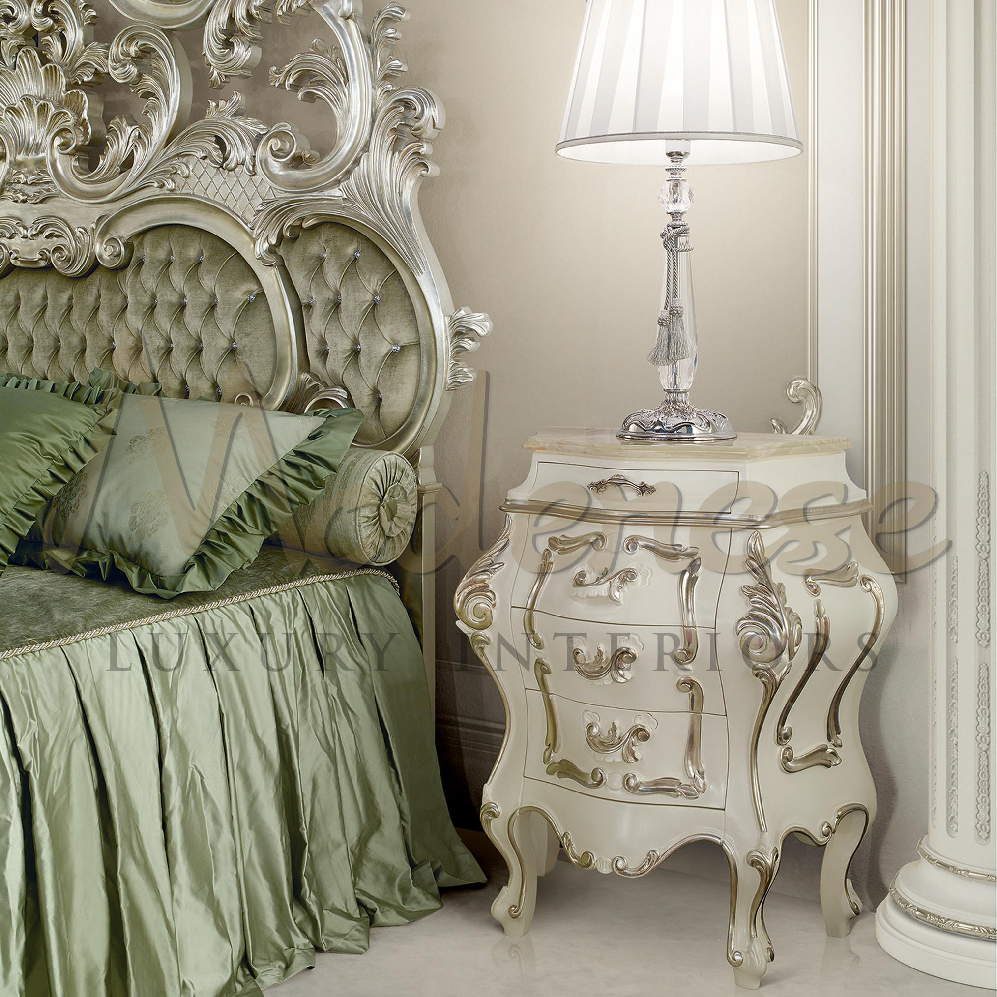 Wonderfully carved baroque night stand by Modenese Luxury Interiors in ivory lacquered finish with silver leaf handmade decorations. This figurated item, which is good in luxury bedrooms alongside beds, dressing tables and credenzas, features four