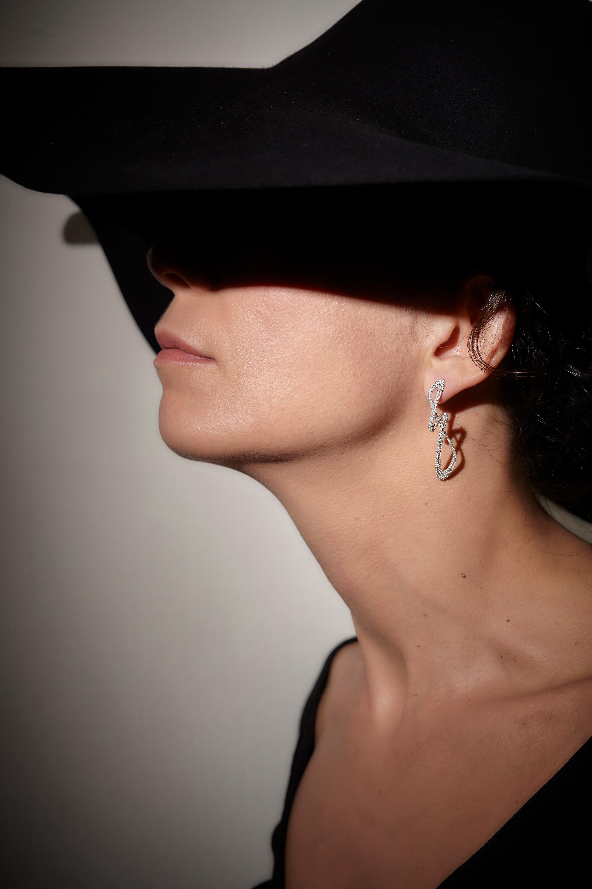 18k White Gold Diamond Pave Made in Italy Delicate Cosmic Empowering Shape-shifting Ohrringe.
Die Gemini Dangle Earrings, inspiriert von der himmlischen Schönheit und energetisiert von der Erde, verändern ihre Form und begleiten deine Veränderung
