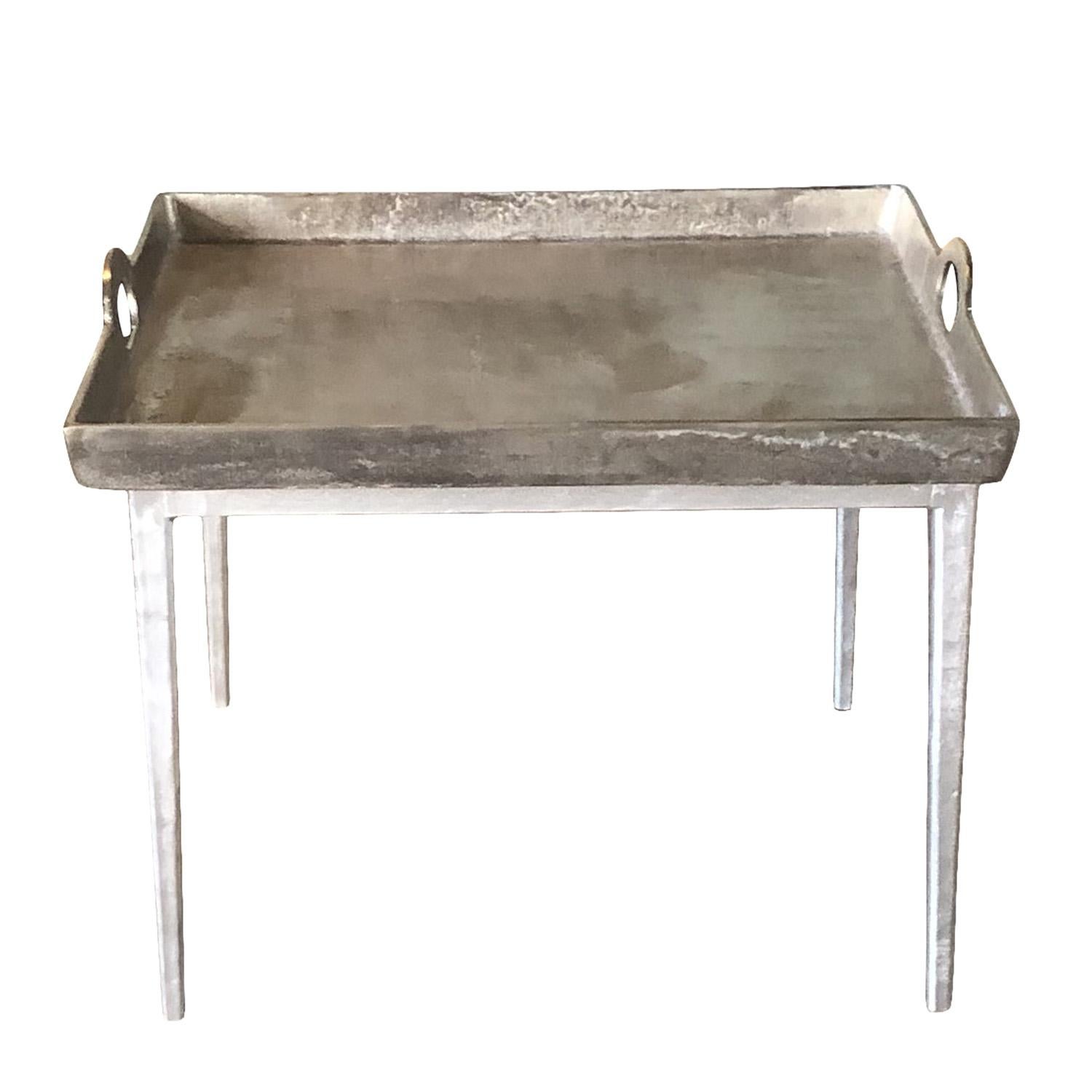Ein belgischer Beistelltisch mit gehämmertem Aluminiumtablett mit seitlichen Griffen auf konischen Metallbeinen. Alters- und gebrauchsbedingte Abnutzungserscheinungen. Circa 21. Jahrhundert, Belgien.