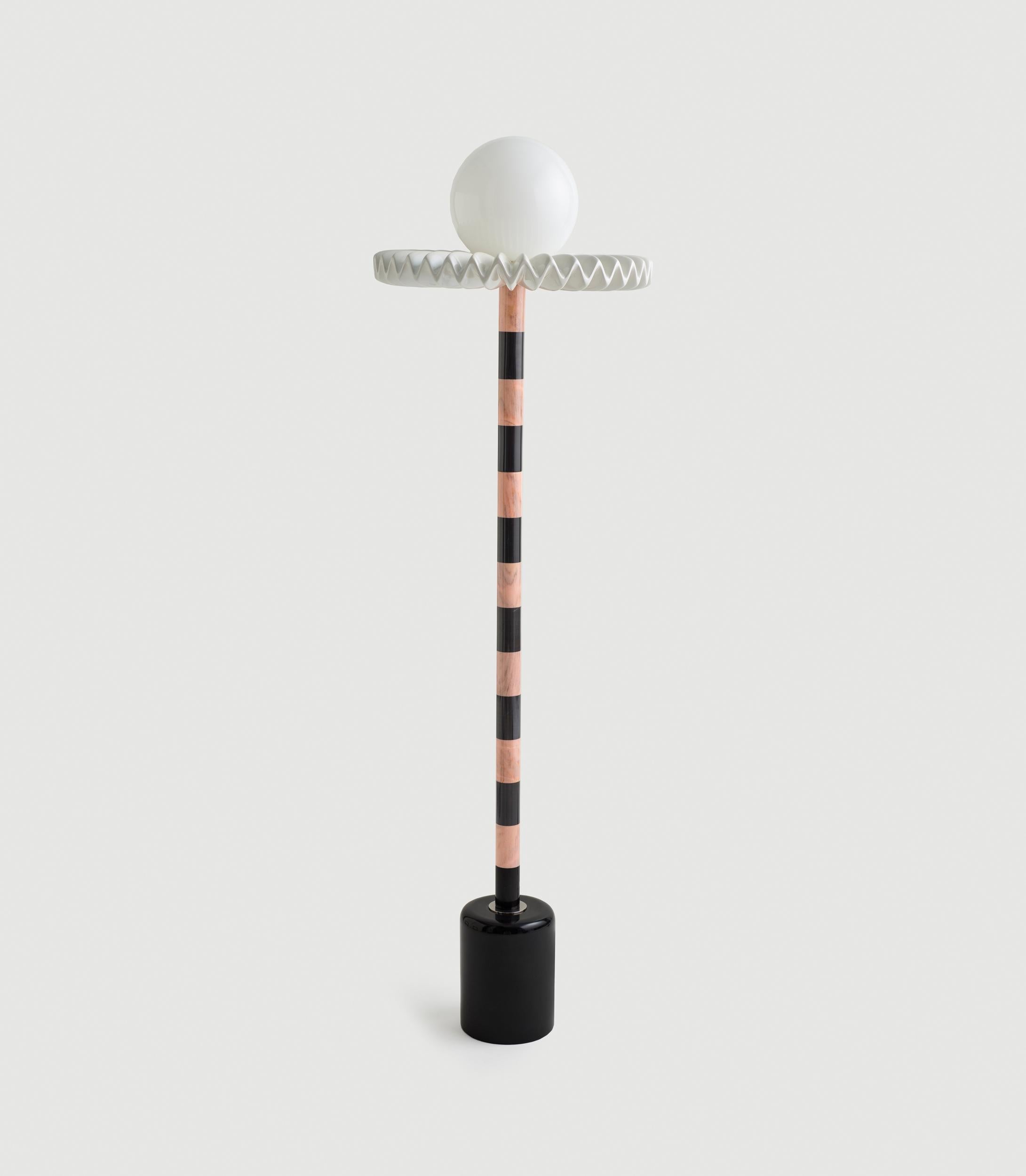 “Sare” is a floor lamp inspired by the 17th century ruff collar which was a symbol of wealth and status. It also resembles the silent clown “Pierrot” with it’s striped marble body and round glass head. Sare is handcrafted and assembled with