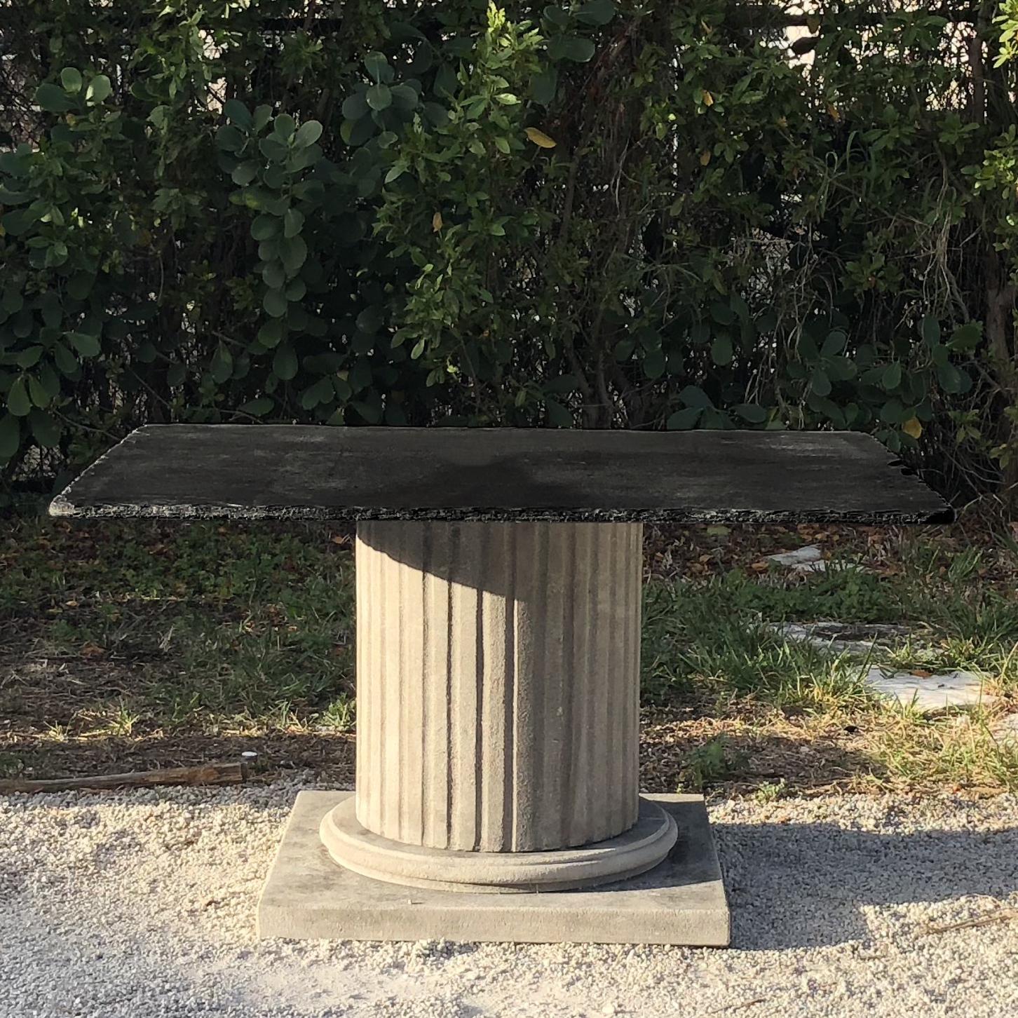 A French garden table with a limestone column raised on a fine square base and a slate table top with uneven edges, in good condition. Wear consistent with age and use. Circa 21st Century, France. 