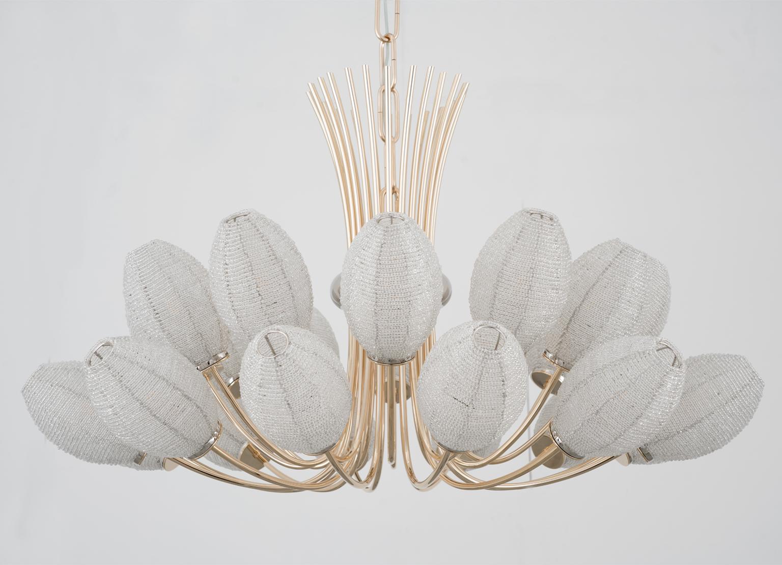Three thousand six hundred twenty eight pearls, one strand. Candid lampshades that remind of precious buds whose design combines the delicacy and the strength of a full bloom together, stopping time a moment before it took place. A way to preserve