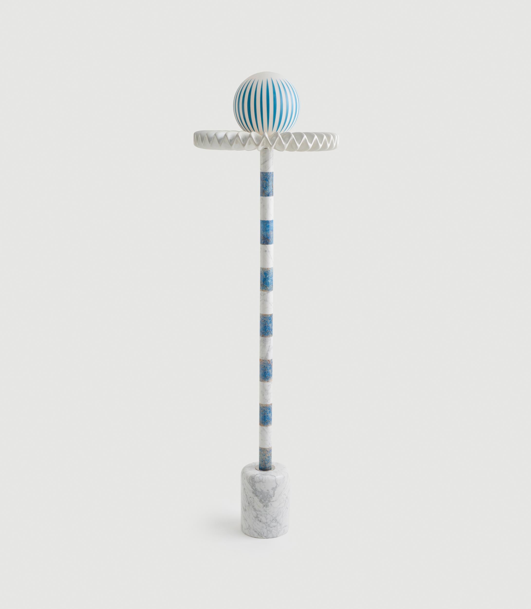 “Sare” is a floor lamp inspired by the 17th Century ruff collar which was a symbol of wealth and status. It also resembles the silent clown “Pierrot” with it’s striped marble body and round glass head. Sare is handcrafted and assembled with