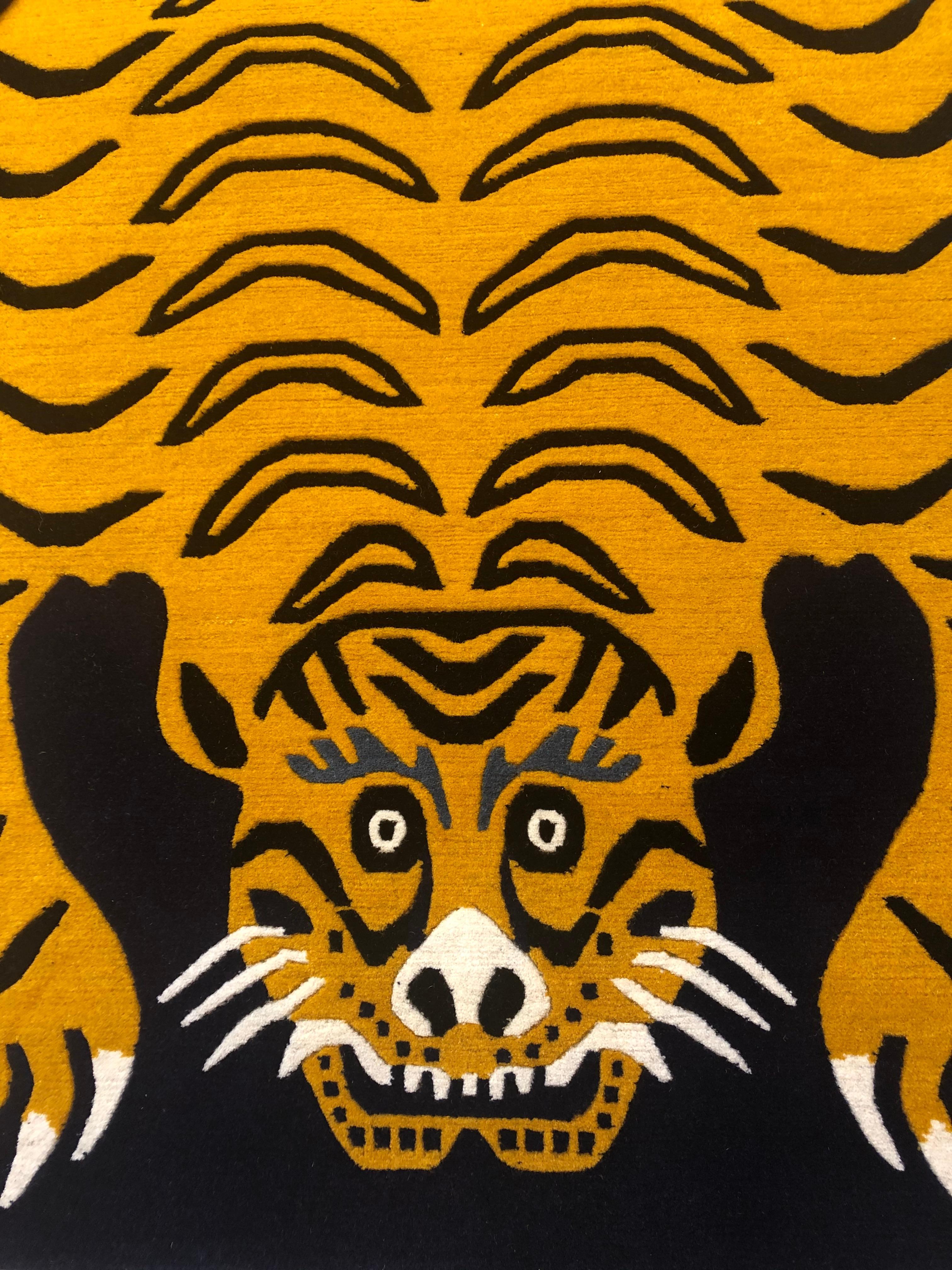 Carpet made of Nepal with hand-spun Himalayan wool and Tibetan knot. The background is midnight blue and the tiger represented has the back richly decorated in the traditional ocher yellow of the fur of these felines. The face expresses strength but