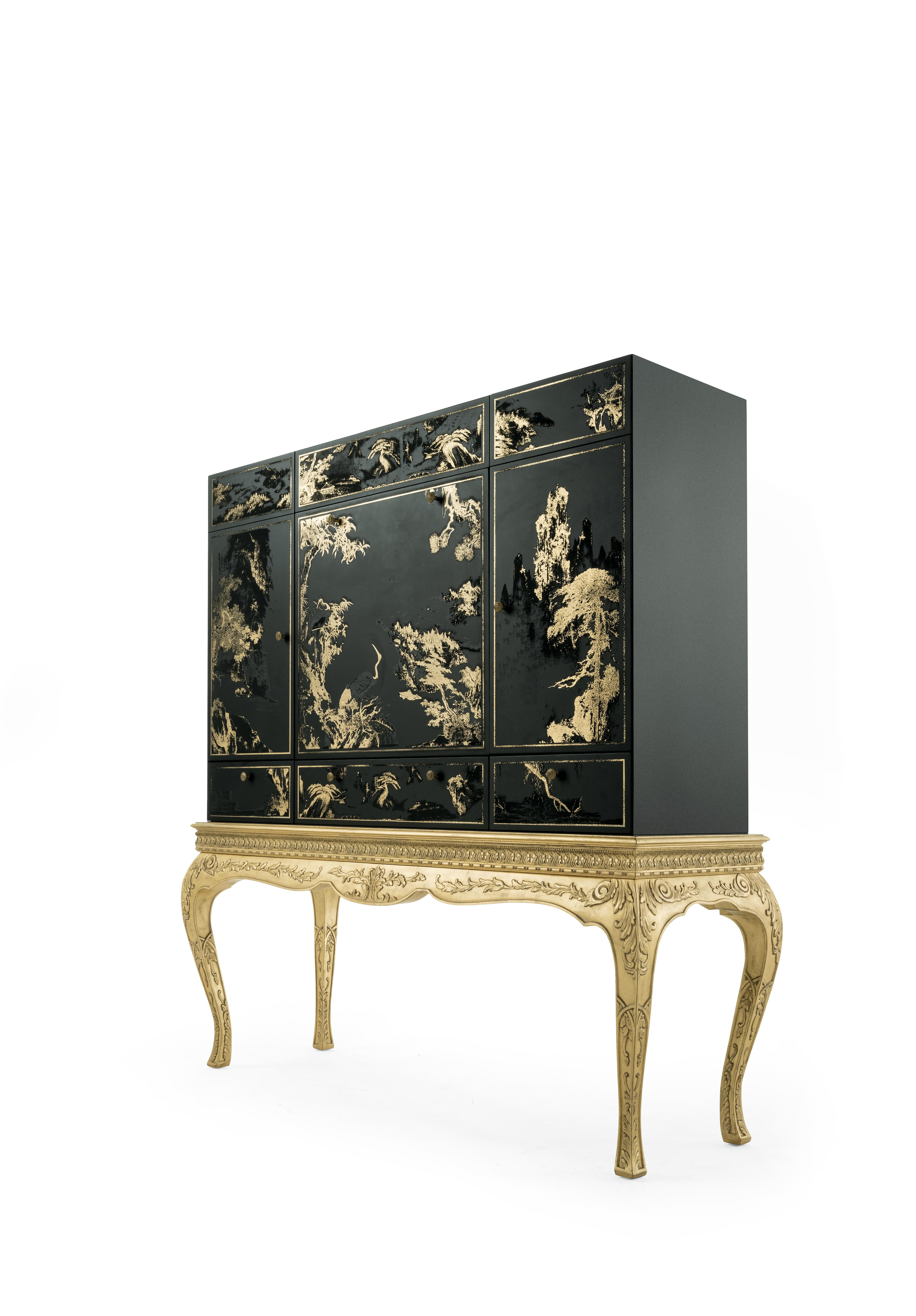 Brocart is a precious and decorative bar cabinet where classic style meets oriental inspirations. The hand-carved legs and decorative frame finished in patinated antique gold recall the baroque style, while the structure in black lacquered wood with