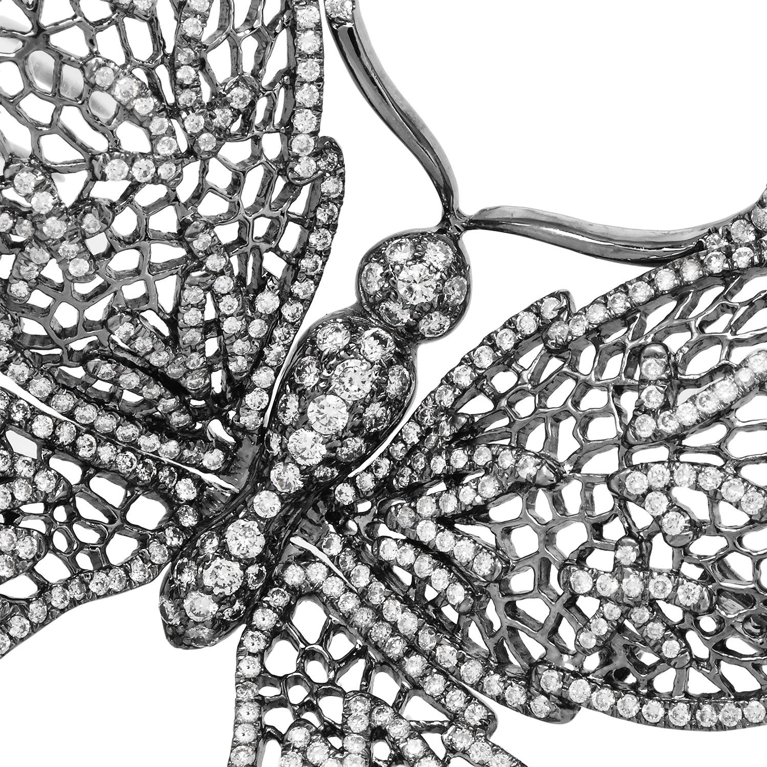 Questa spilla a farfalla è realizzata in oro annerito a 18 carati, creando un contrasto drammatico con un campo abbagliante di diamanti naturali a taglio brillante. Il disegno traforato delle ali è incorniciato da bordi di diamanti incastonati, che