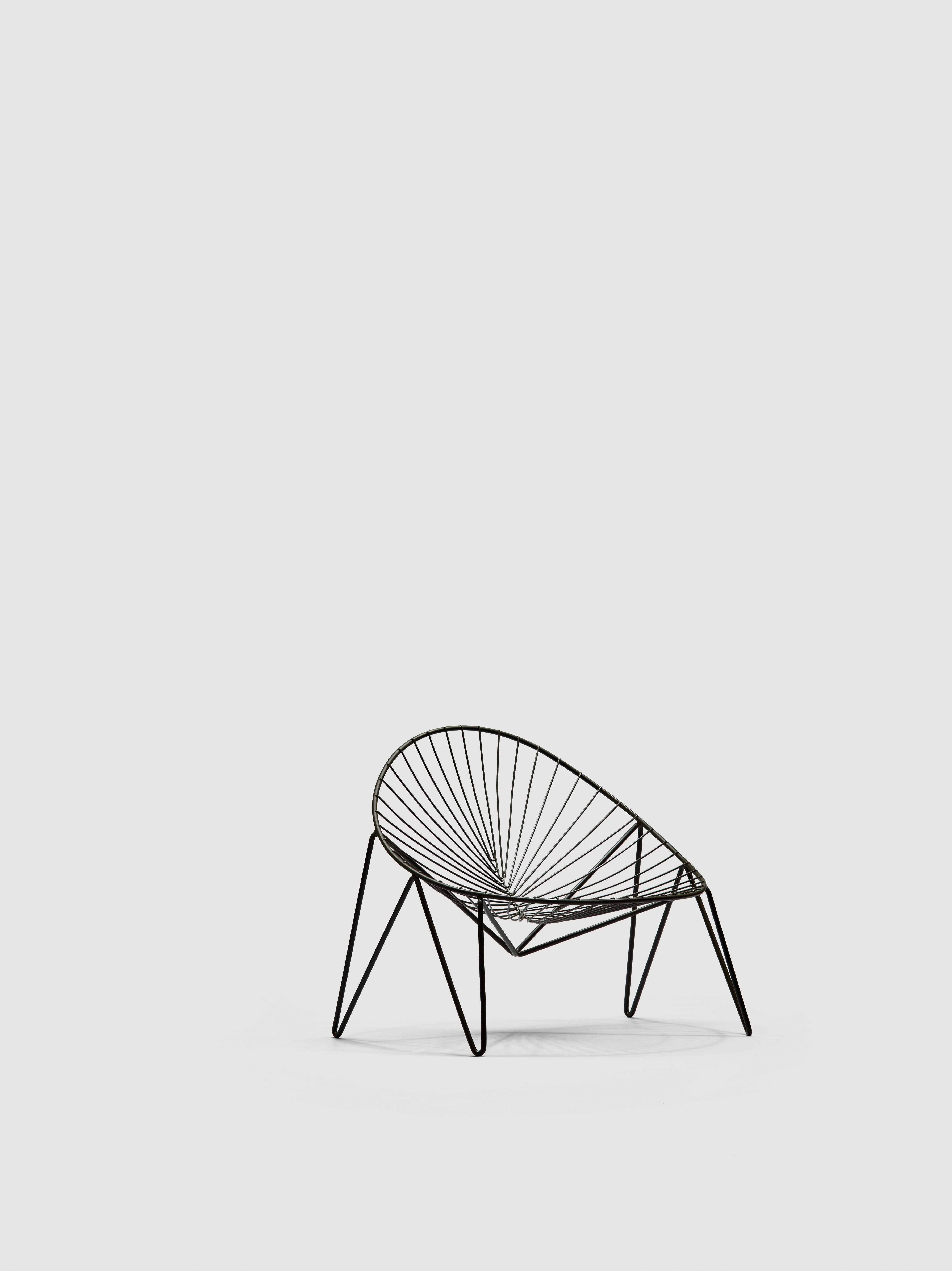 Indoor-outdoor lounge chair, frame in round steel tube, seat and backrest in contoured round steel rod.