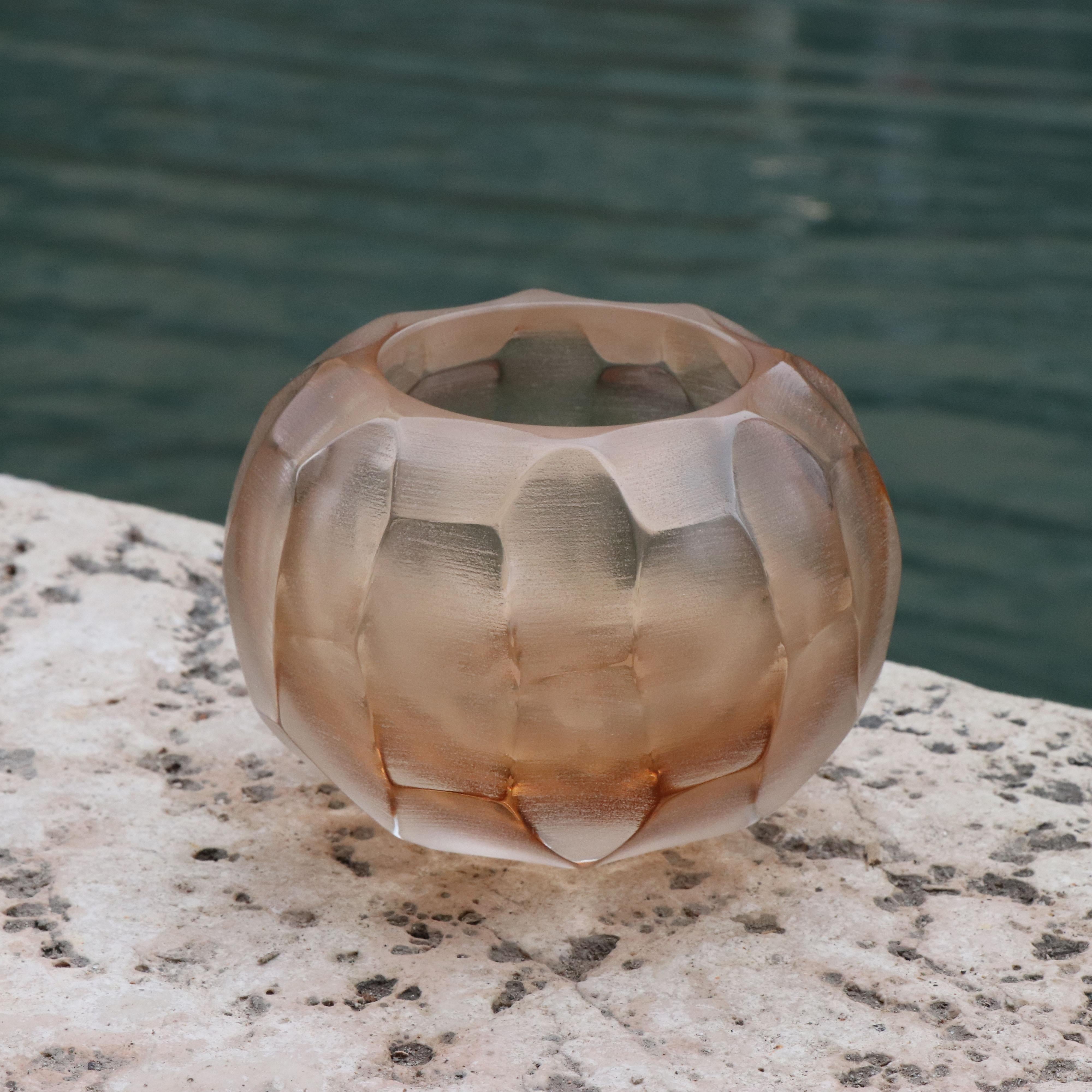 This small vase is called Bocia - a word from the Venetian dialect which means ‘little one’. Its round shape is achieved by first mouth blowing the molten glass. Once cooled the surface is finished with carving and polishing techniques revealing