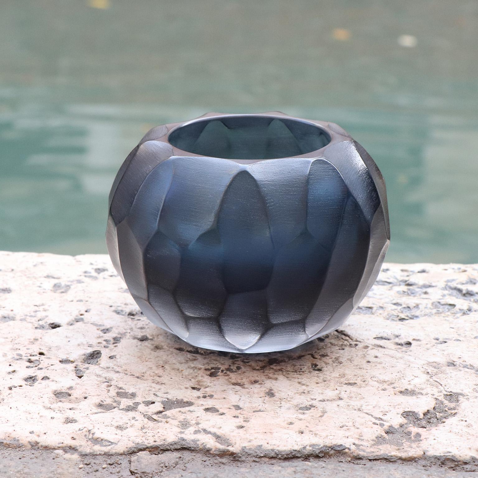 This small vase is called Bocia, a word from the Venetian dialect which means ‘little one’. Its round shape is achieved by first mouth blowing the molten glass. Once cooled the surface of the vase is finished with carving and polishing techniques