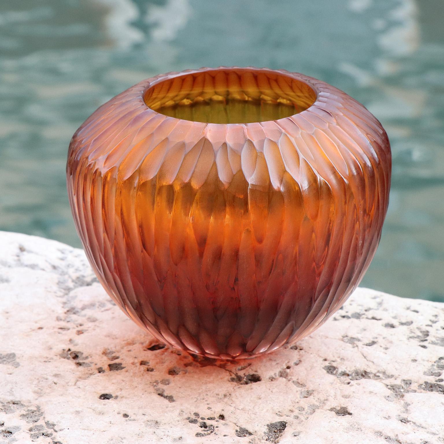 Inspired by the ancient amphorae, this vase resembles the elongated form of a drop, which in Italian translates as Goccia. Following the blowing process the vase is engraved and polished producing a vibrant faceted surface.

This vase is