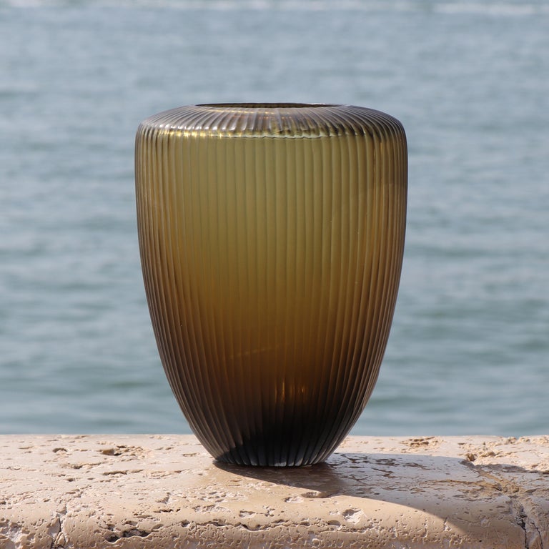Inspired by the ancient amphorae, this vase resembles the elongated form of a drop, which in Italian translates as Goccia. Following the blowing process, the vase is engraved and polished producing a vibrant faceted surface.

This vase is