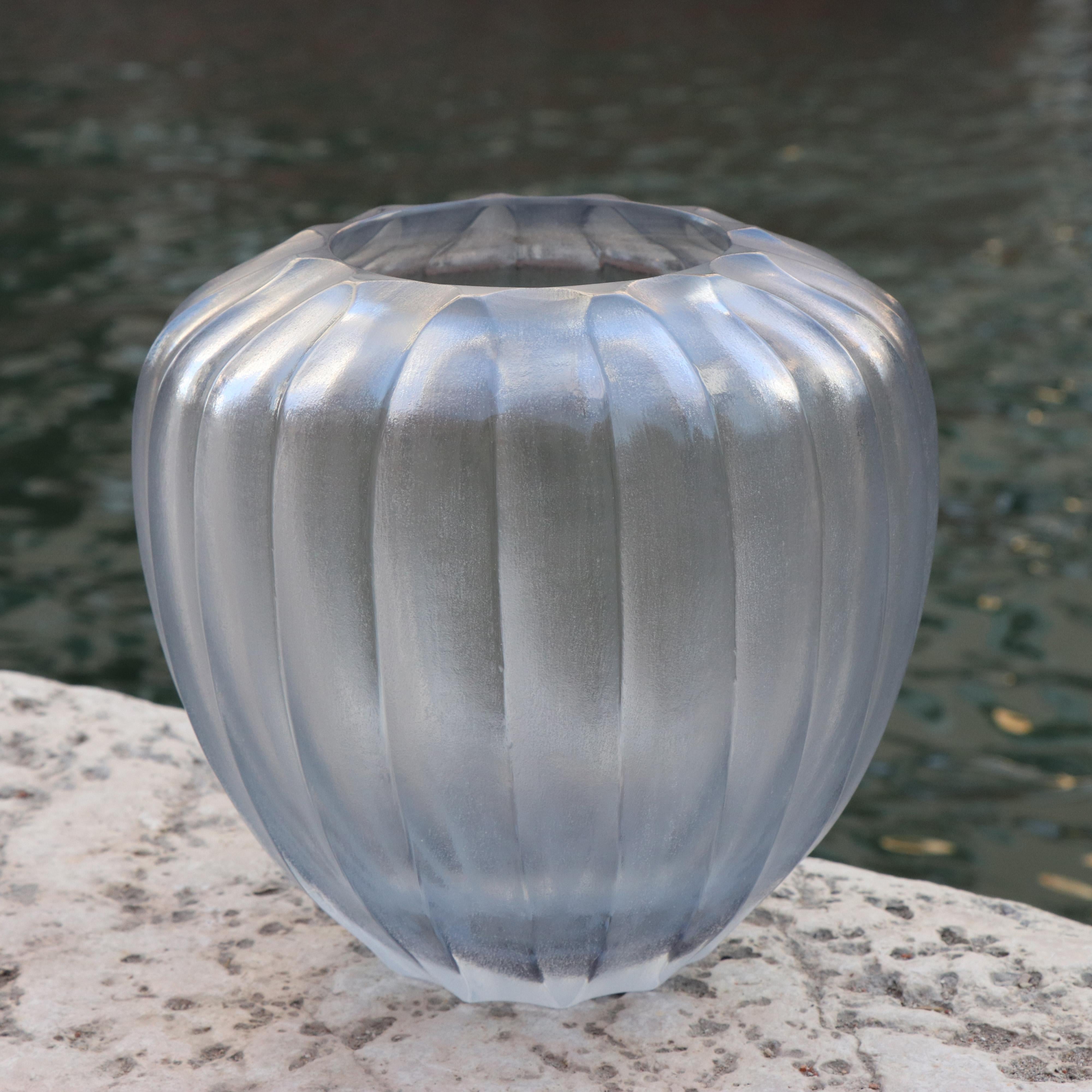 Inspired by the ancient amphorae, this vase resembles the elongated form of a drop – which in Italian translates as Goccia. Following the blowing process the vase is engraved and polished producing a vibrant faceted surface.

This vase is
