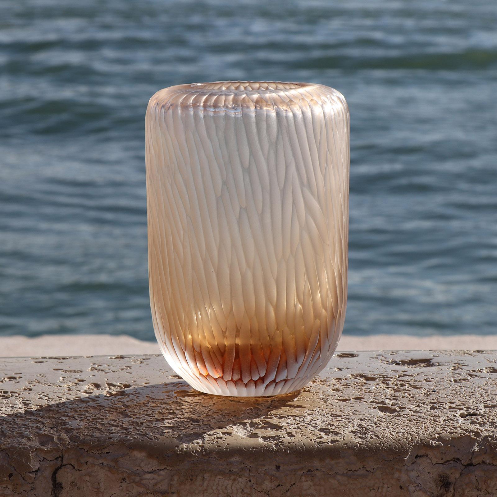 The name Rullo evokes the act of rolling the heated glass on the blow pipe. This small vase is first shaped by blowing the molten glass and further modelled by carving the surface once cooled. The vibrations of the light on the etched surface are