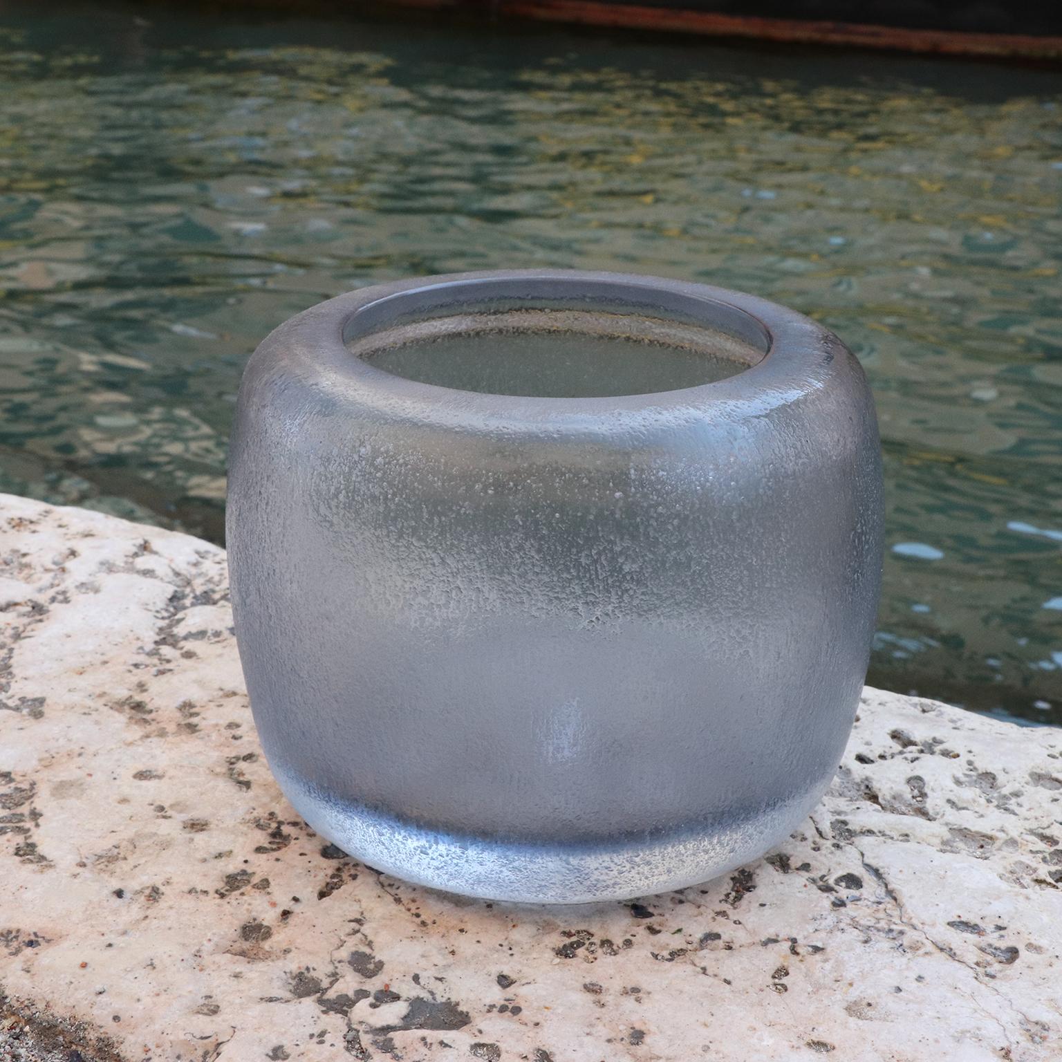 Defined by its sturdy, rotund body, the design of this vase recalls the Venetian water wells – Pozzo. Following the blowing process the vase is cold worked with carving and polishing techniques which completely transforms the visual and tactile