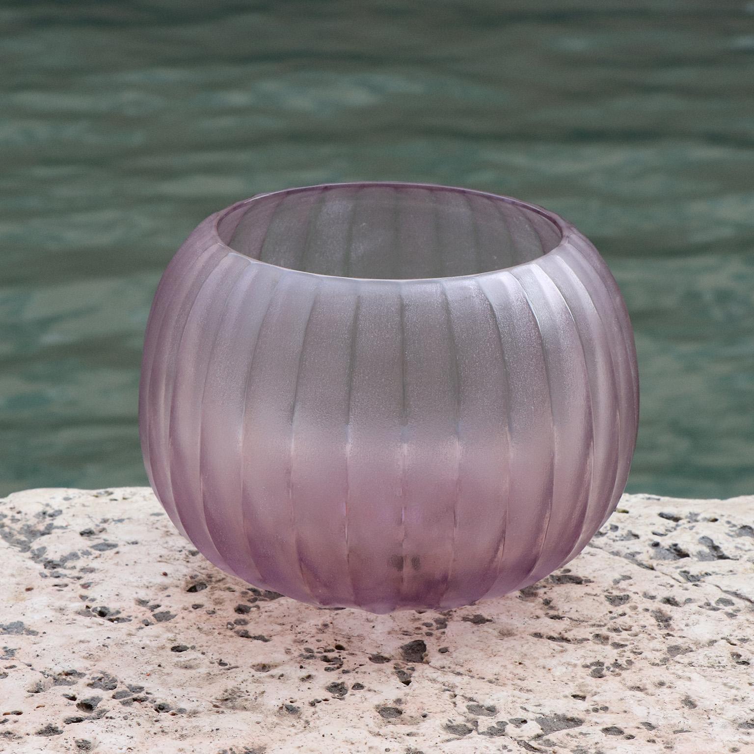 Playfully named Puffo this vase has a round ‘pouf-like’ shape. To achieve the desired form and dimensions the molten glass is first mouthblown. Once cooled the surface is transformed by a laborious cold carving process called ‘molatura’ lending the