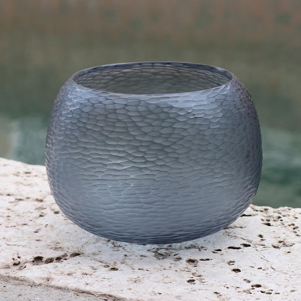 Playfully named Puffo this vase has a round ‘pouf-like’ shape. To achieve the desired form and dimensions the molten glass is first mouthblown. Once cooled the surface is transformed by a laborious cold carving process called ‘molatura’ lending the