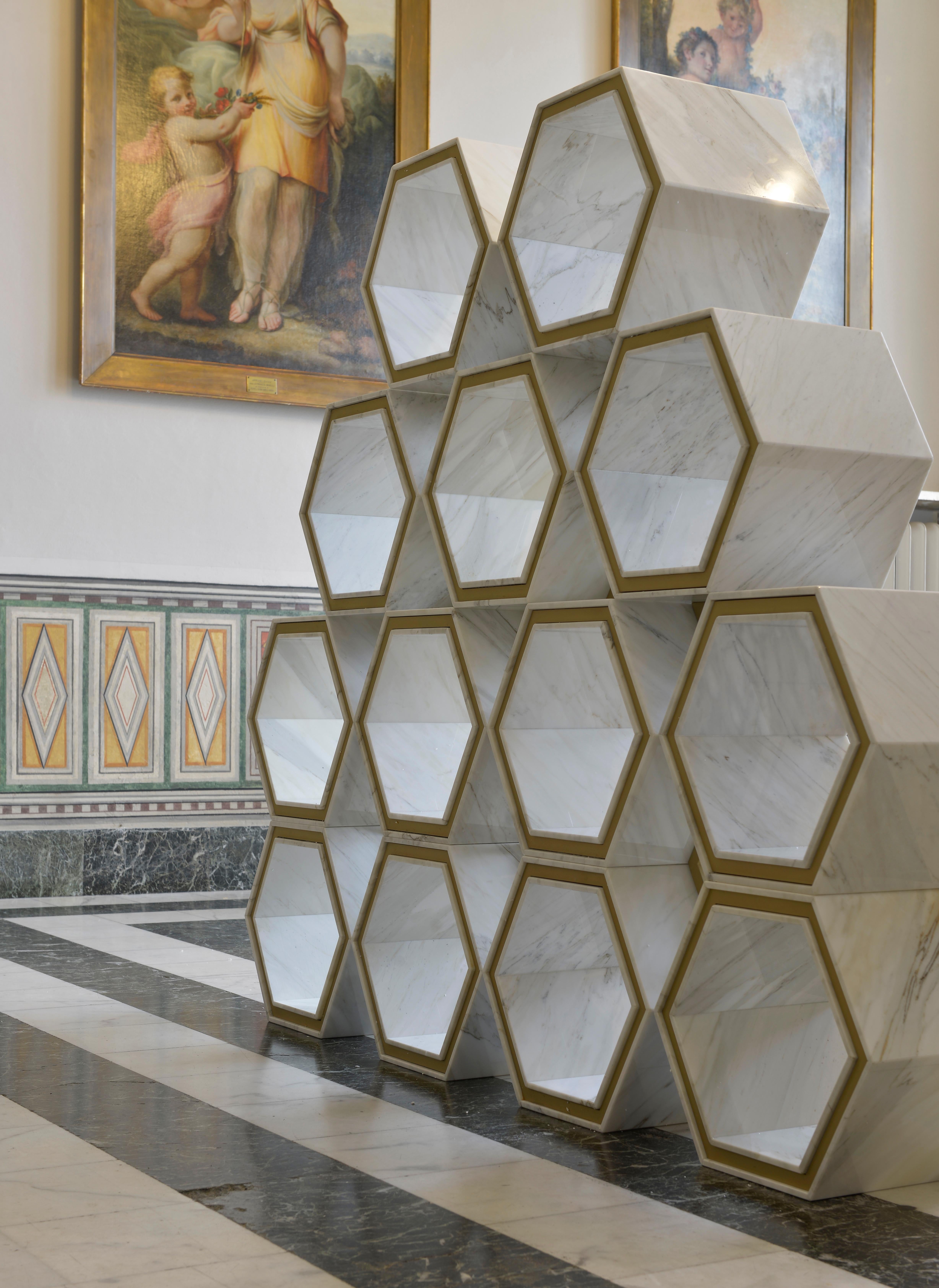 L'une des innombrables façons dont la bibliothèque hexagonale peut être utilisée pour structurer élégamment l'espace et accueillir des objets. Cette élégante bibliothèque de forme hexagonale est une combinaison de métal doré et de marbre qui dégage
