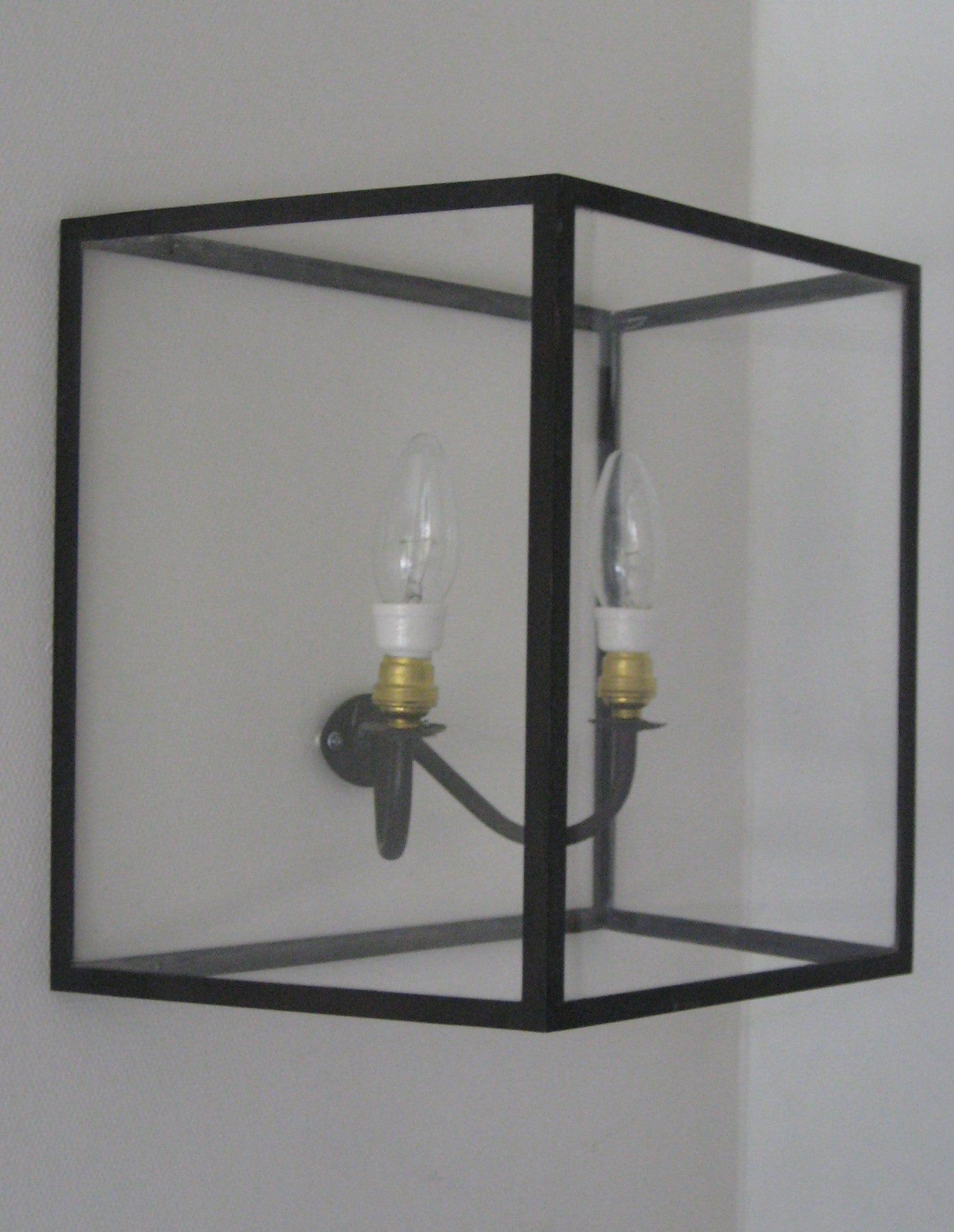 This wall light is made of brass profiles which are chemically blackened. Glass in front and sides. provided of 2 candle lamps e14 leds. Front is 25x30 cm.