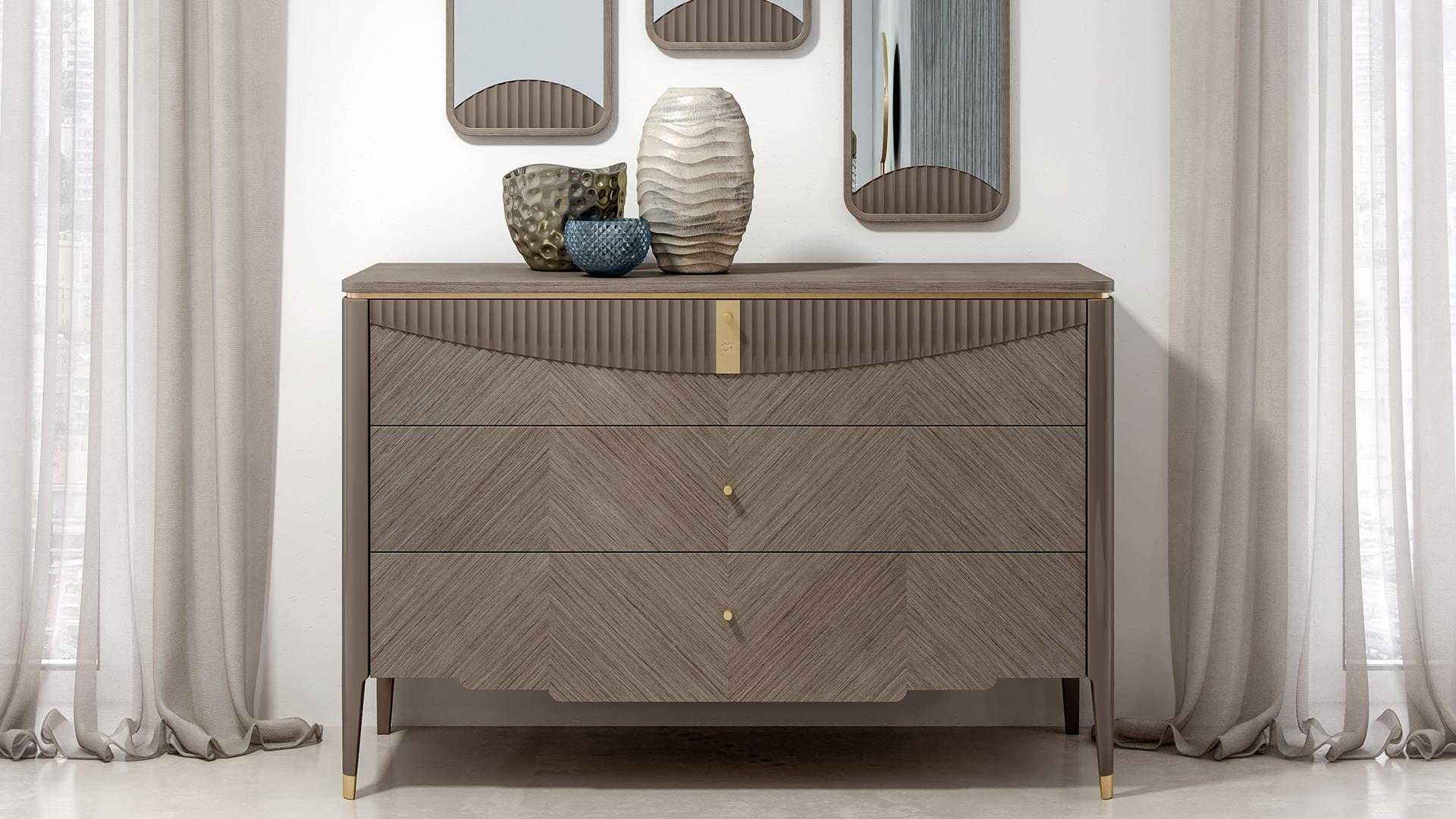 Three drawers chest of drawers. The beautiful mix between natural Walnut wood and golden galvanic metal details is perfect for a Contemporary and luxurious environment . The lacquered wave decor on the front gives a touch of style to the piece. On