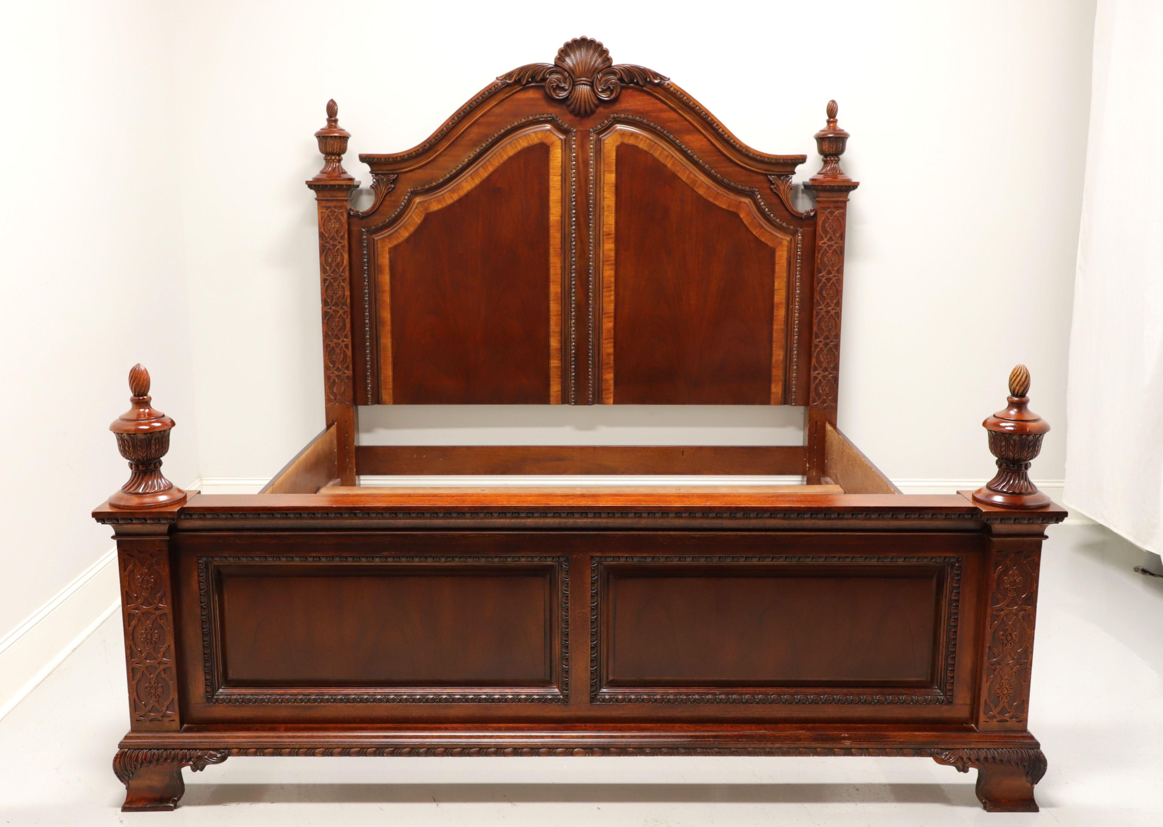 A king size panel bed in the Traditional Victorian style, unbranded. Mahogany with veneers. Tall headboard has an arced top with carved shell to center and decorative fretwork to square side posts with large finials. Low footboard with wide flat top