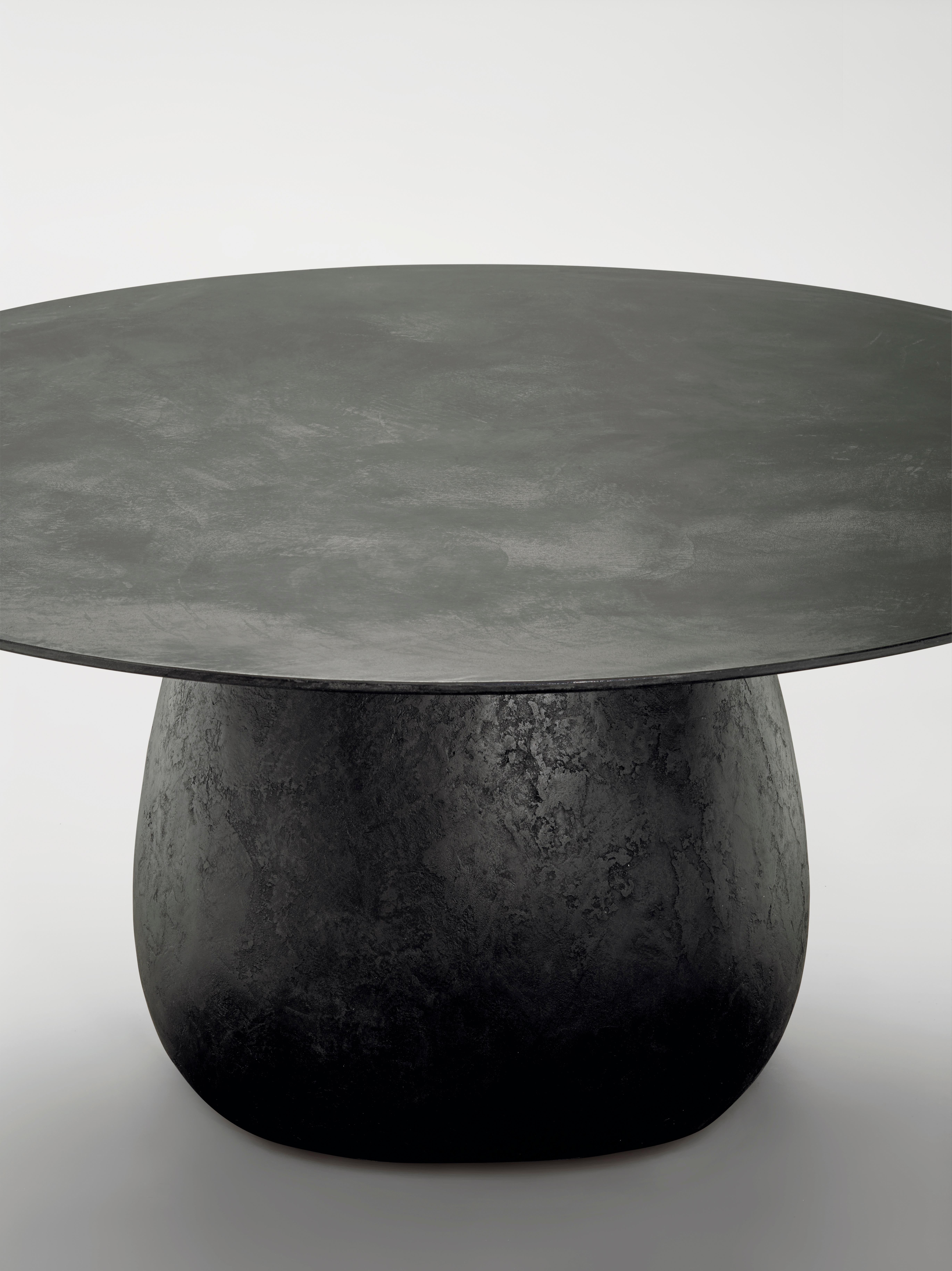 Indoor-outdoor table, moulded rigid polyurethane base with internal central leg in steel, purenit top. Base and top entirely coated with a hand-trowelled mixture of lava stone