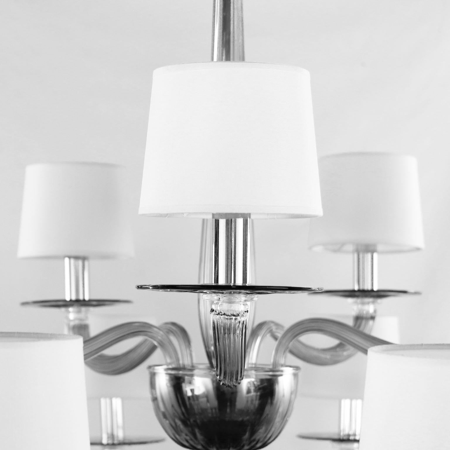 Serenade Kronleuchter mit 10+5 Lichtern aus grauem Muranoglas und weißen, handgefertigten Baumwolllampenschirmen von Multiforme.
Die Kollektion Serenade ist von einem zeitgenössischen und internationalen Design inspiriert, das einfach, aber nicht