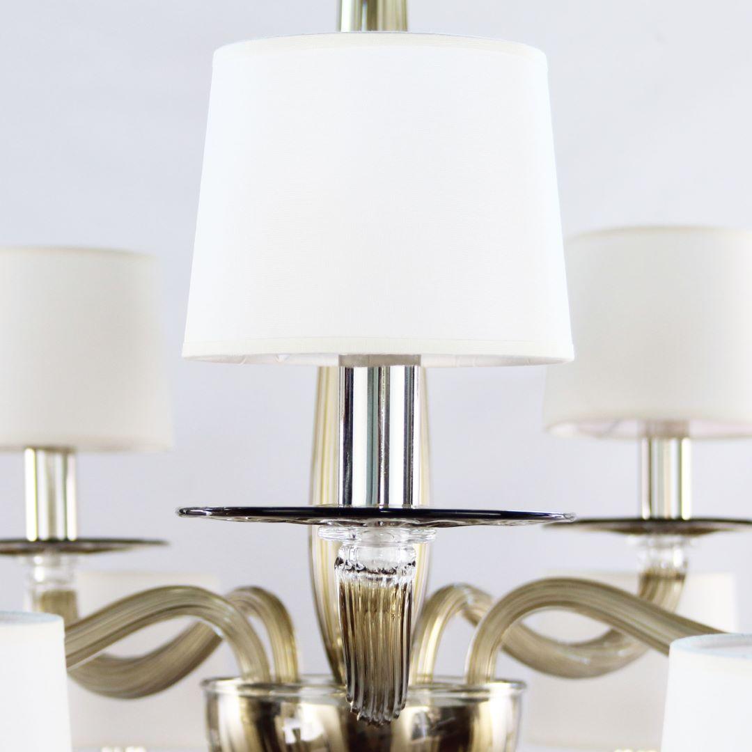 Serenade chandelier 10+5 walnut Murano glass, white handmade cotton lampshades by Multiforme.
Serenade collection is inspired by a contemporary and international design, simple but not banal, and consists of elements studied in minute detail. The